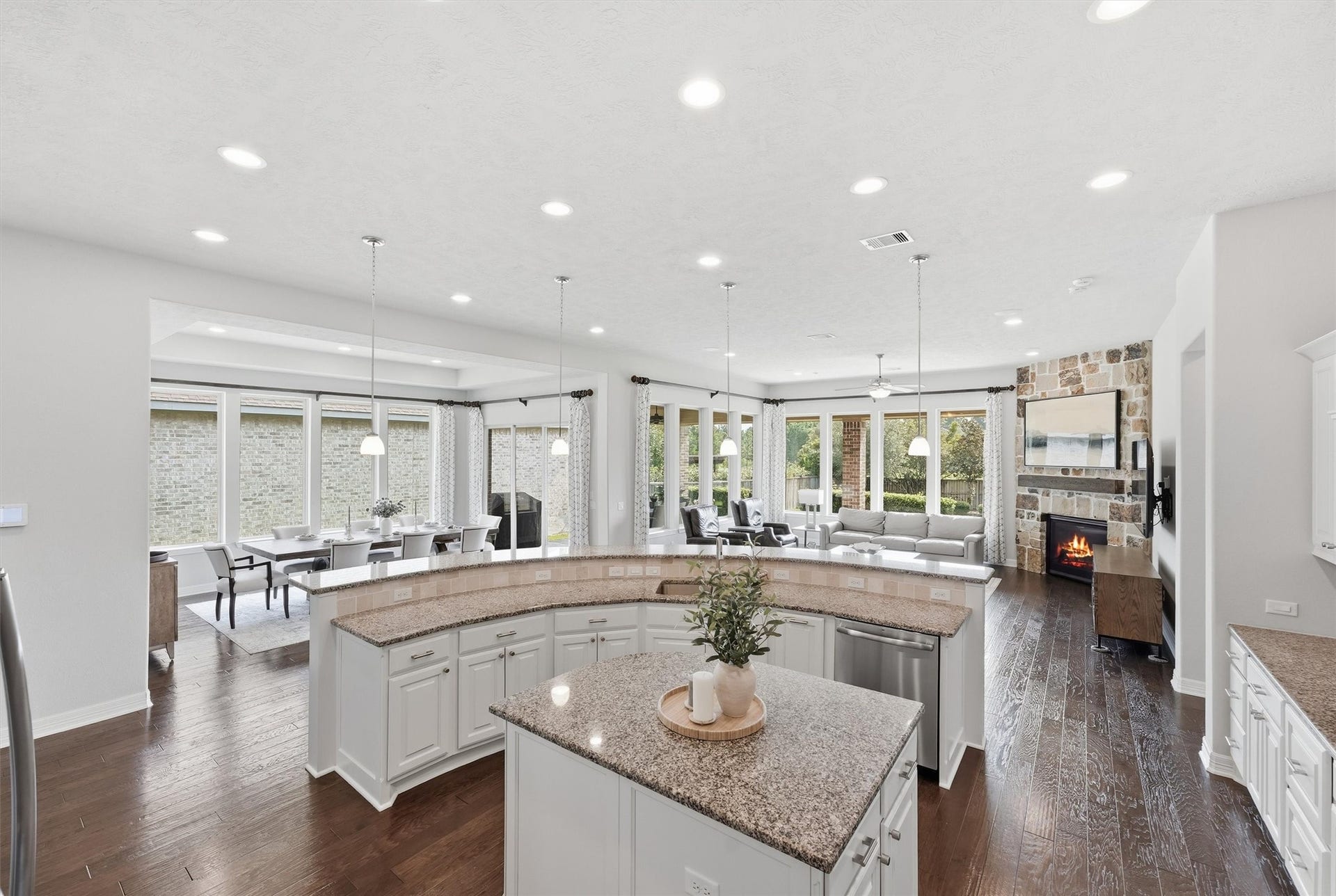 This home features an open-concept layout with seamless views from the kitchen throughout the dining and living areas, creating the perfect space for family gatherings and entertaining guests.