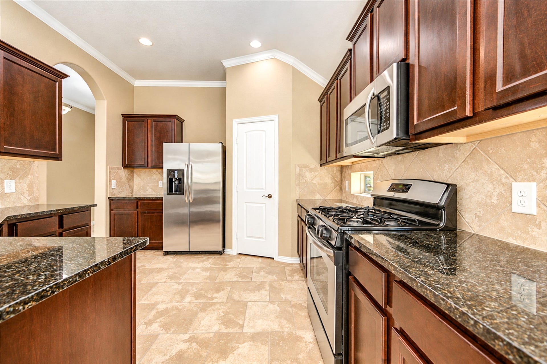 16719 Cactus Blossom Trail, Cypress, TX 77433 Stainless appliances, granite counters and a gas range sit within generous cabinetry in the kitchen.