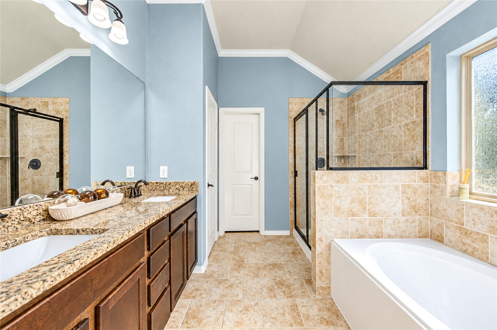 16719 Cactus Blossom Trail, Cypress, TX 77433 The primary bath pairs a granite vanity with a separate tiled walk-in shower and a soaking tub.
