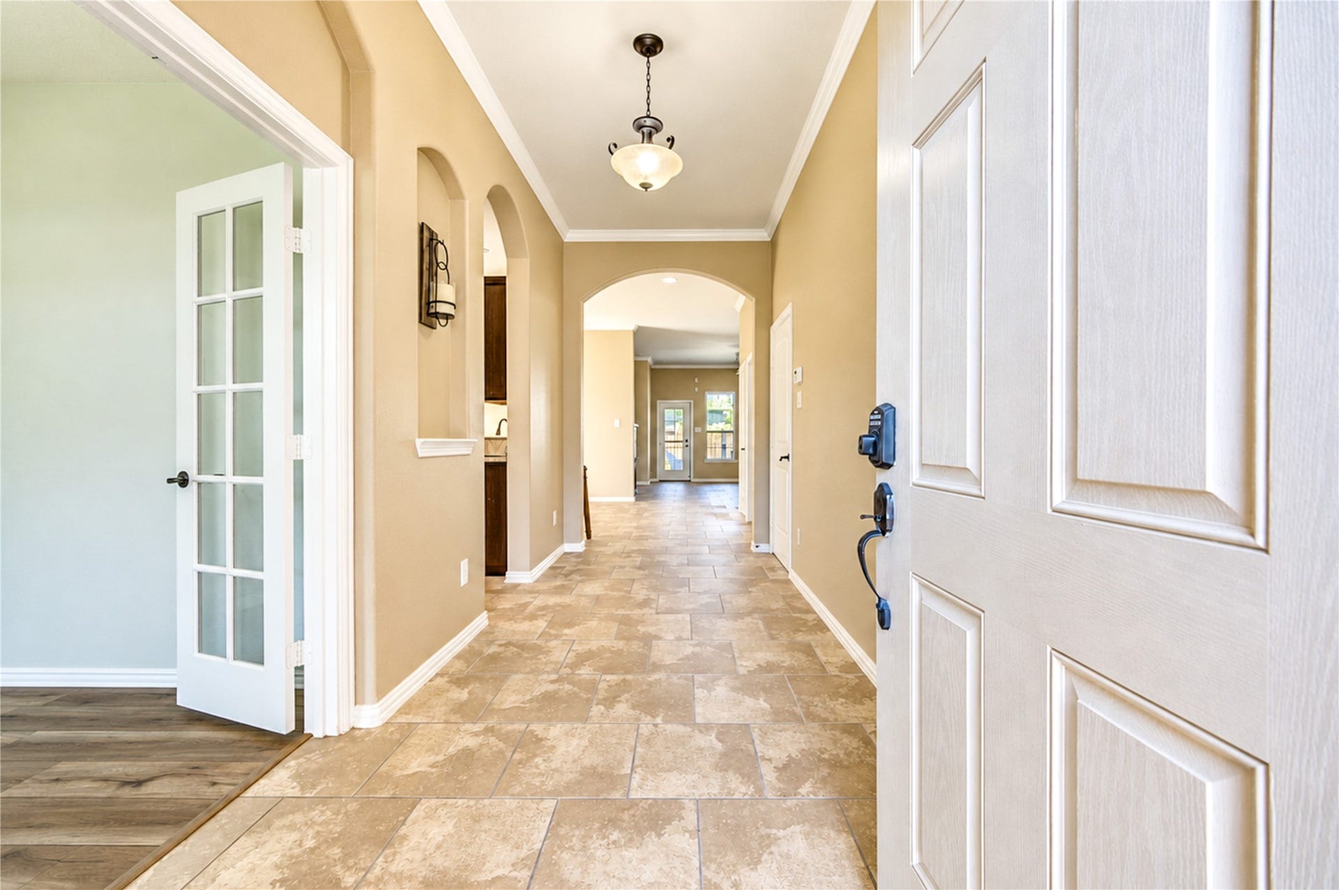 16719 Cactus Blossom Trail, Cypress, TX 77433 Arched niches and a glass-paneled door at the study line the gallery hall leading to the open living spaces.