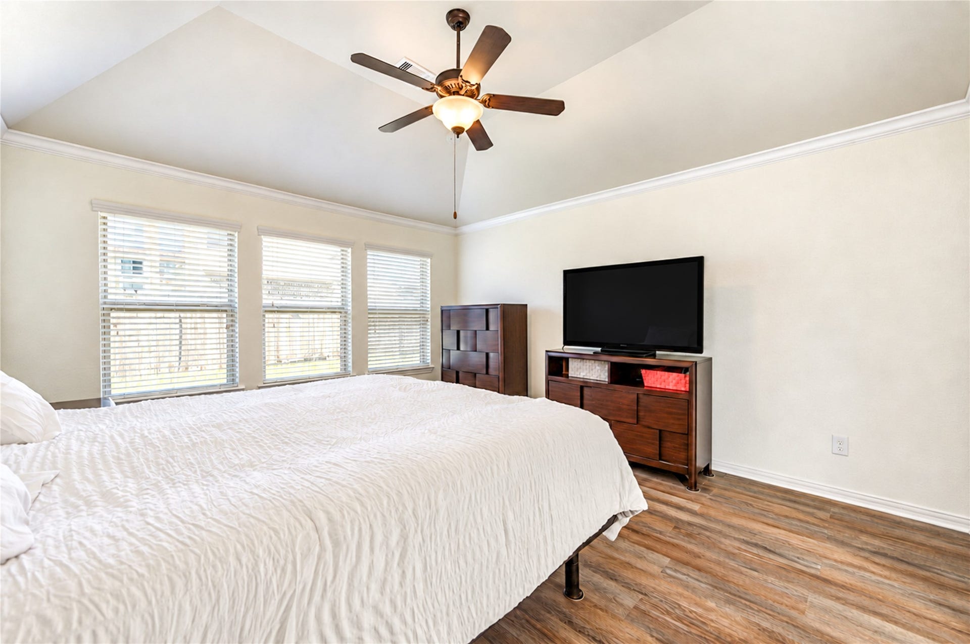 16719 Cactus Blossom Trail, Cypress, TX 77433 Triple windows fill the primary bedroom with light beneath a high, angled ceiling.