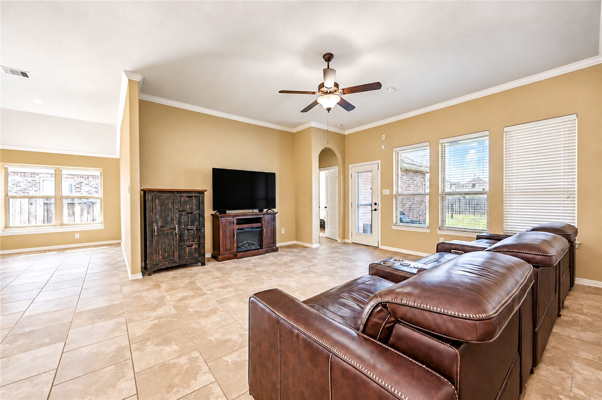 16719 Cactus Blossom Trail, Cypress, TX 77433 Large windows and a glass door bring natural light to the living room and its view of the backyard.