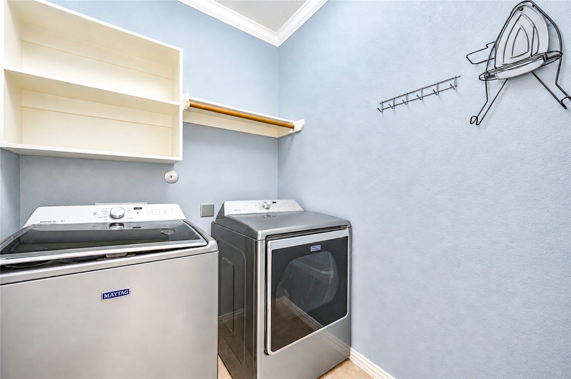 16719 Cactus Blossom Trail, Cypress, TX 77433 The laundry room has built-in shelving, a hanging rod and space for a full-size washer and dryer.