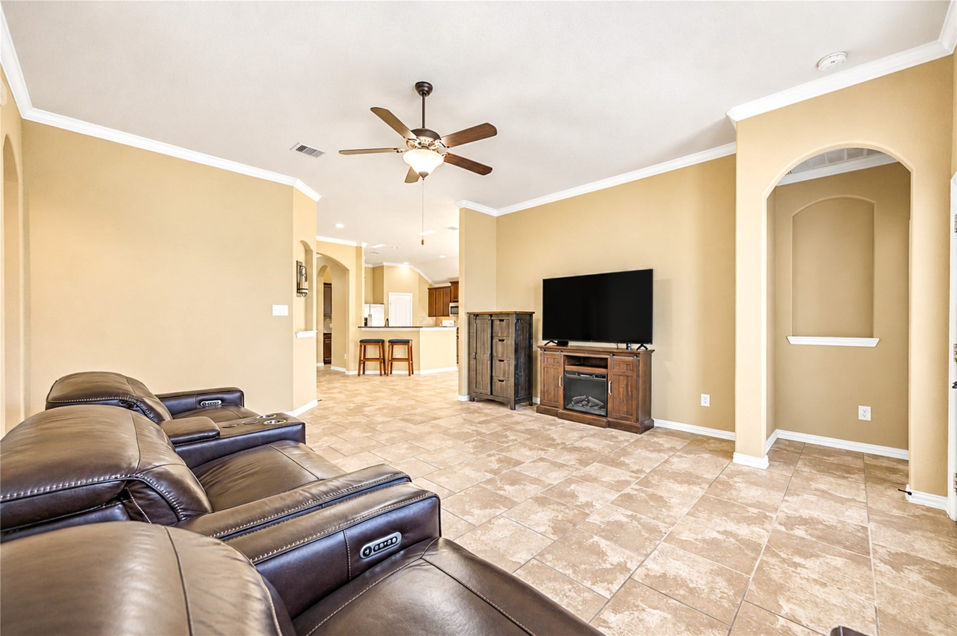 16719 Cactus Blossom Trail, Cypress, TX 77433 The living room opens to the kitchen and breakfast area, with an arched niche and a ceiling fan overhead.