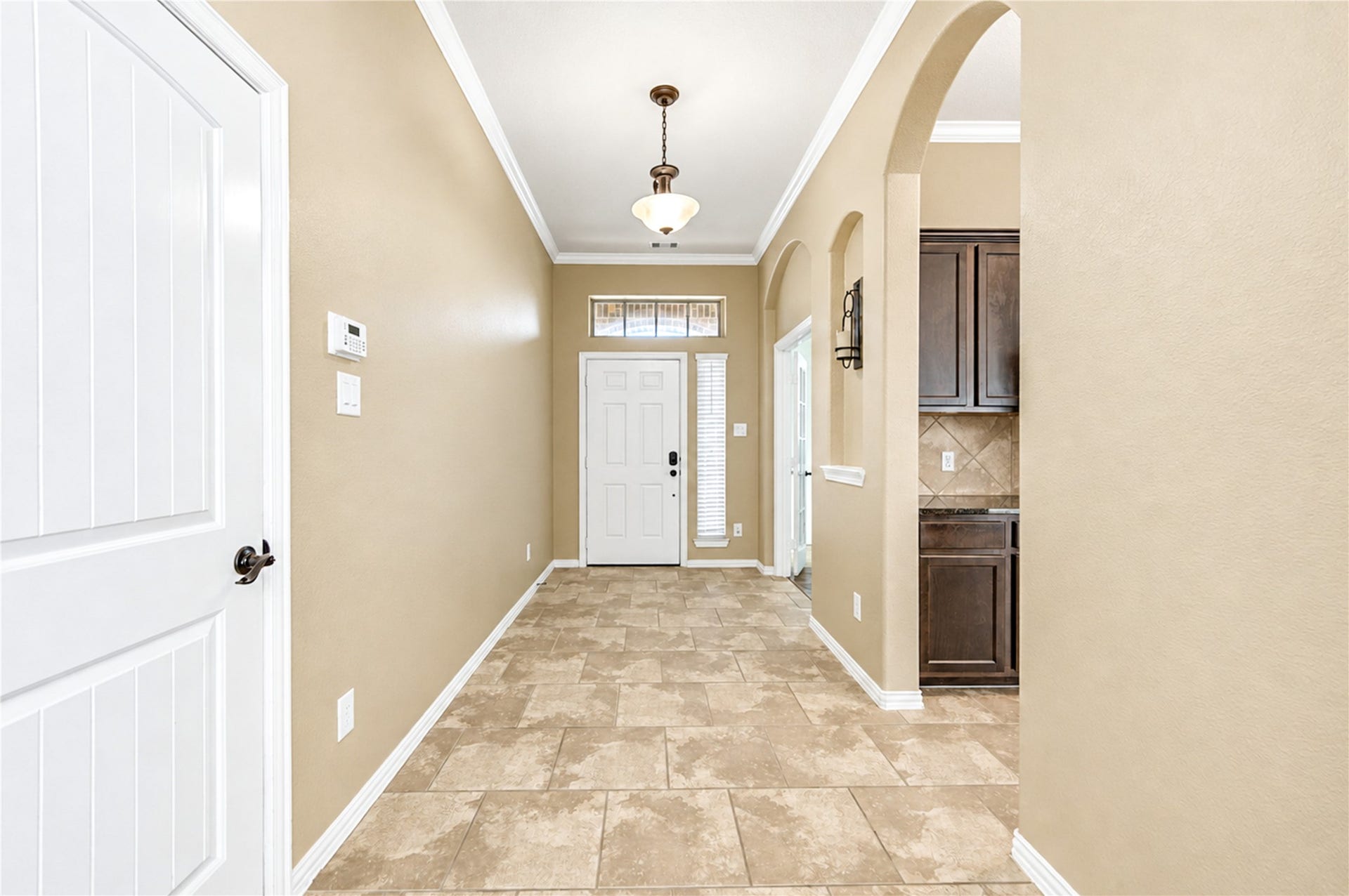 16719 Cactus Blossom Trail, Cypress, TX 77433 The tiled entry foyer opens through an arched passage toward the kitchen and the back of the home.