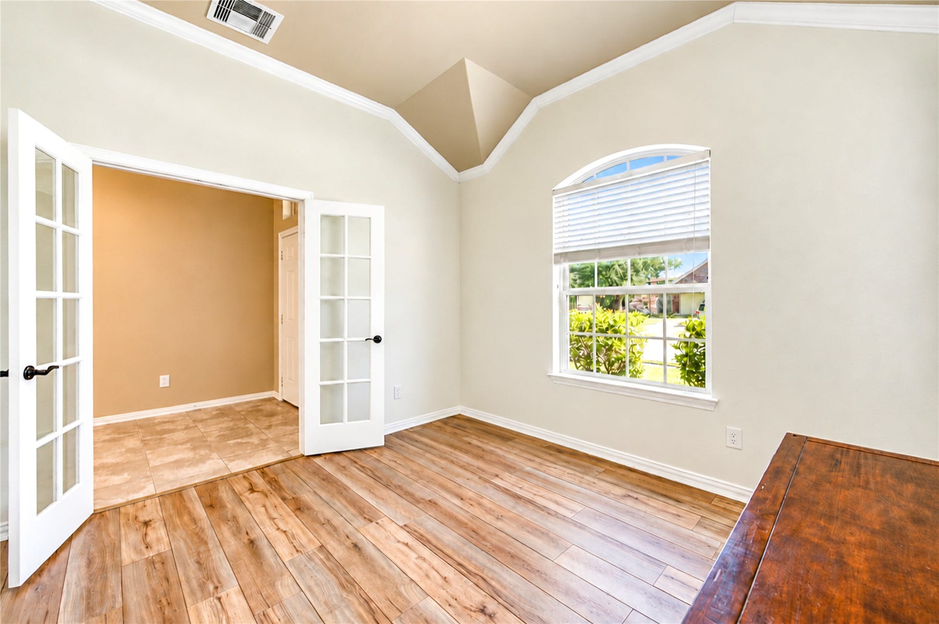 16719 Cactus Blossom Trail, Cypress, TX 77433 French doors open to the home office, where luxury vinyl plank flooring and an arched window create a quiet workspace.