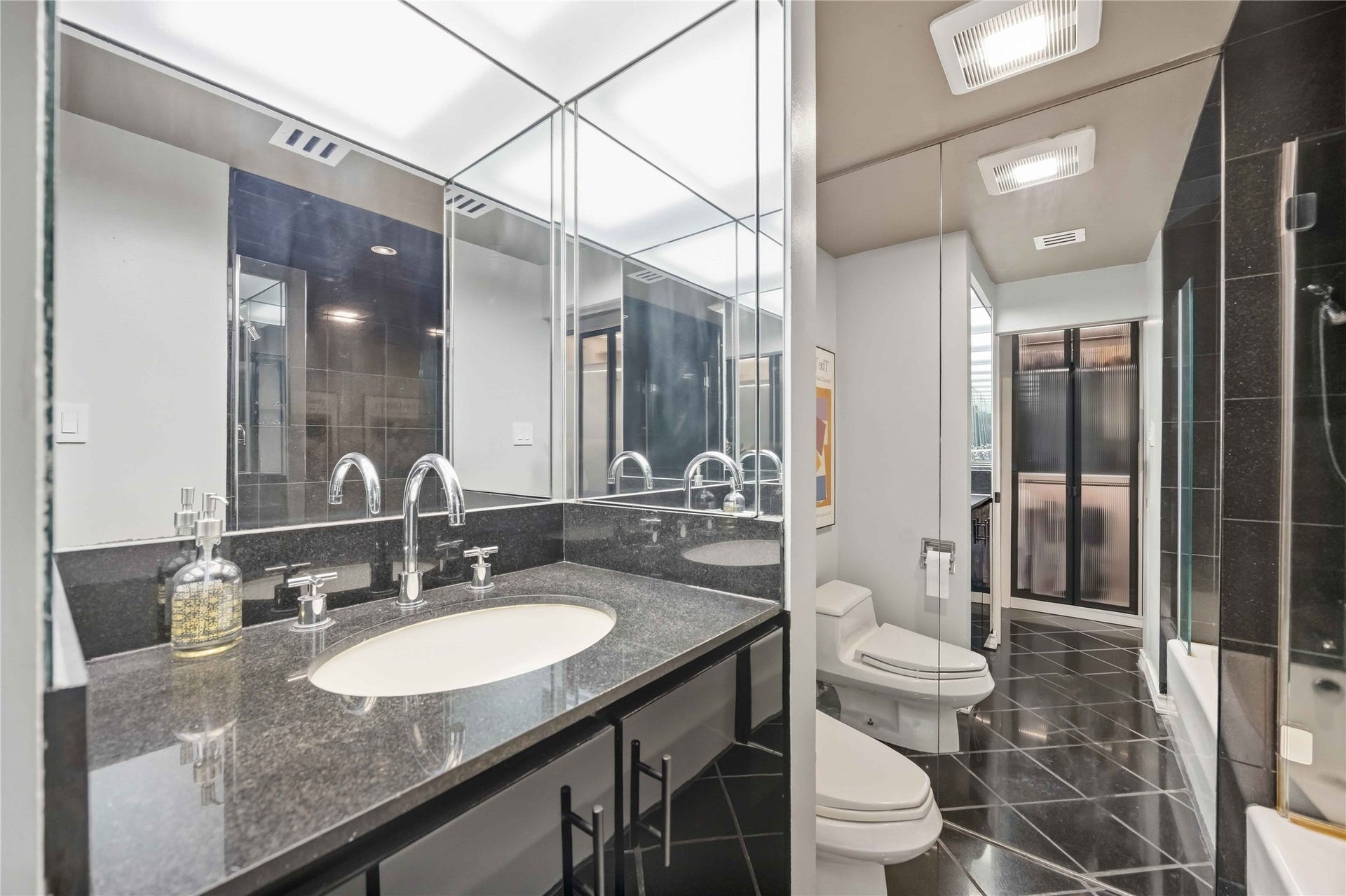 5000 Montrose Boulevard, #6A, Houston, TX 77006 The bathroom features a stone vanity, generous mirrors, and plenty of storage.
