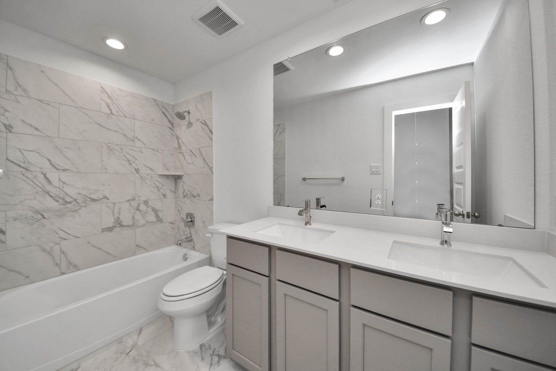 63 Knight Bayou Drive, Dayton, TX 77535 Secondary bath features tile flooring, bath/shower combo with tile surround, light stained wood cabinets, beautiful light countertop. Sample photo of completed home with similar floor plan. Actual colors and selections may vary.