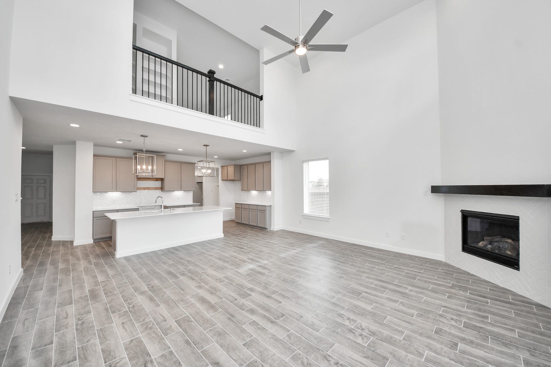 63 Knight Bayou Drive, Dayton, TX 77535 Family room flooded with natural light through the expansive windows. The premium tile flooring adds a touch of luxury to the space, creating the perfect setting for relaxing moments and cherished gatherings with loved ones. Sample photo of completed home with similar floor plan. Actual colors and selections may vary.
