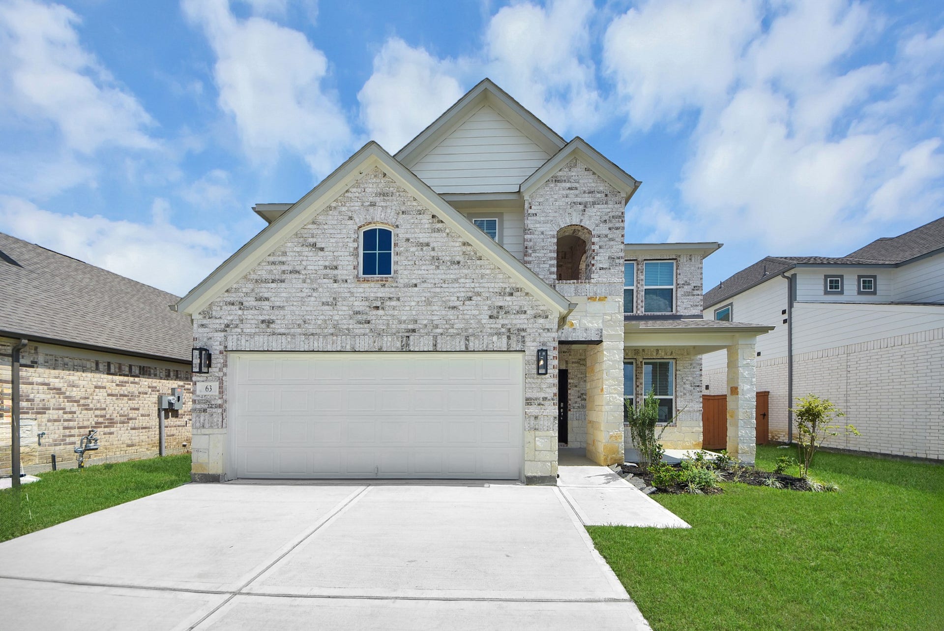 63 Knight Bayou Drive, Dayton, TX 77535 Meticulously maintained yard and lush landscape, paired with a premium elevation featuring captivating brick accents. Modern coach lights add a touch of contemporary elegance to the exterior.