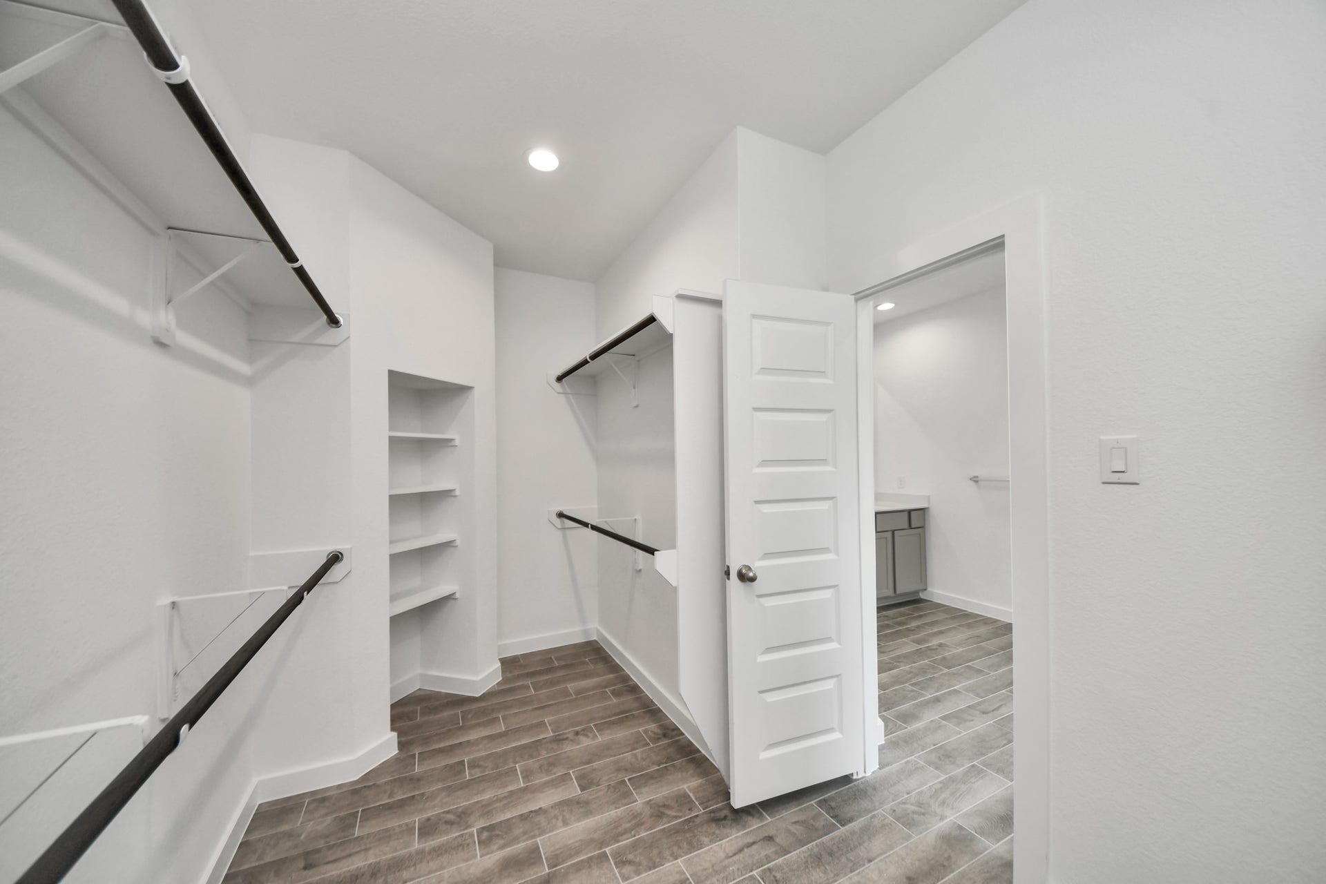 63 Knight Bayou Drive, Dayton, TX 77535 Walk-in closet that epitomizes luxury and practicality. This generously sized space features built-in shelving, offering abundant room for impeccable organization. High ceilings and recessed lighting create a bright and welcoming ambiance. Sample photo of completed home with similar floor plan. Actual colors and selections may vary.