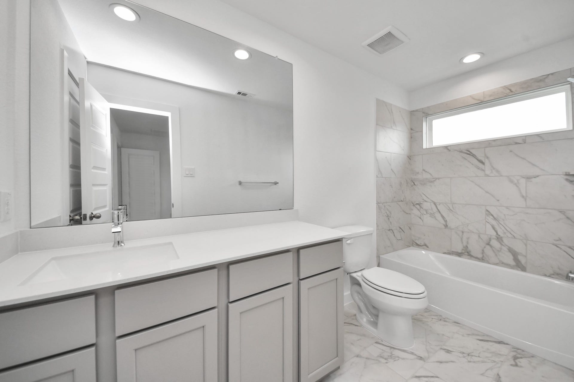 63 Knight Bayou Drive, Dayton, TX 77535 Secondary bath features tile flooring, bath/shower combo with tile surround, light stained wood cabinets, beautiful light countertop. Sample photo of completed home with similar floor plan. Actual colors and selections may vary.