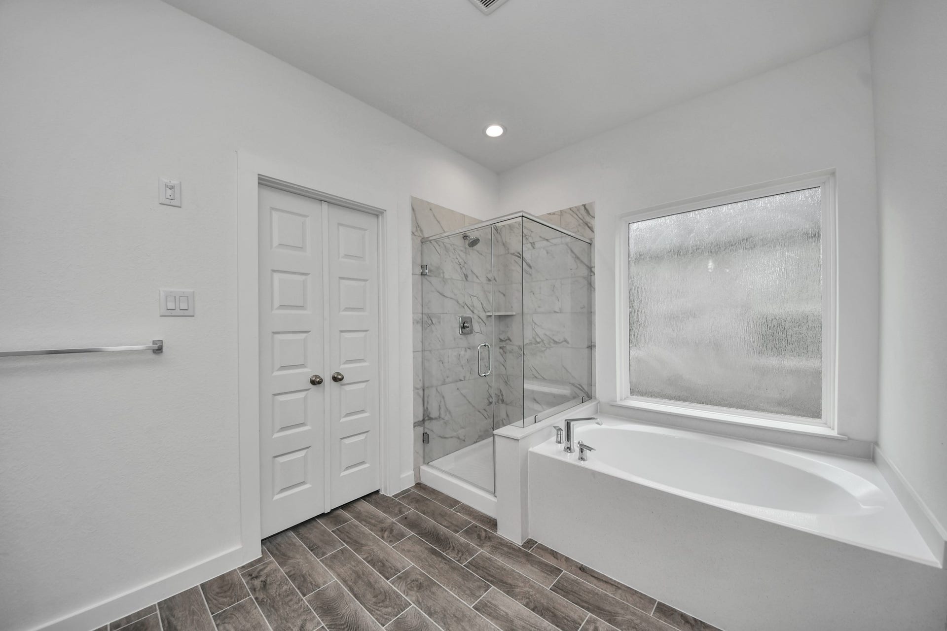 63 Knight Bayou Drive, Dayton, TX 77535 Indulge in a spa-like retreat within the confines of this primary bathroom. Delight in a spacious walk-in shower enveloped in stylish tile surround, unwind in a separate garden tub adorned with custom detailing. Sample photo of completed home with similar floor plan. Actual colors and selections may vary.