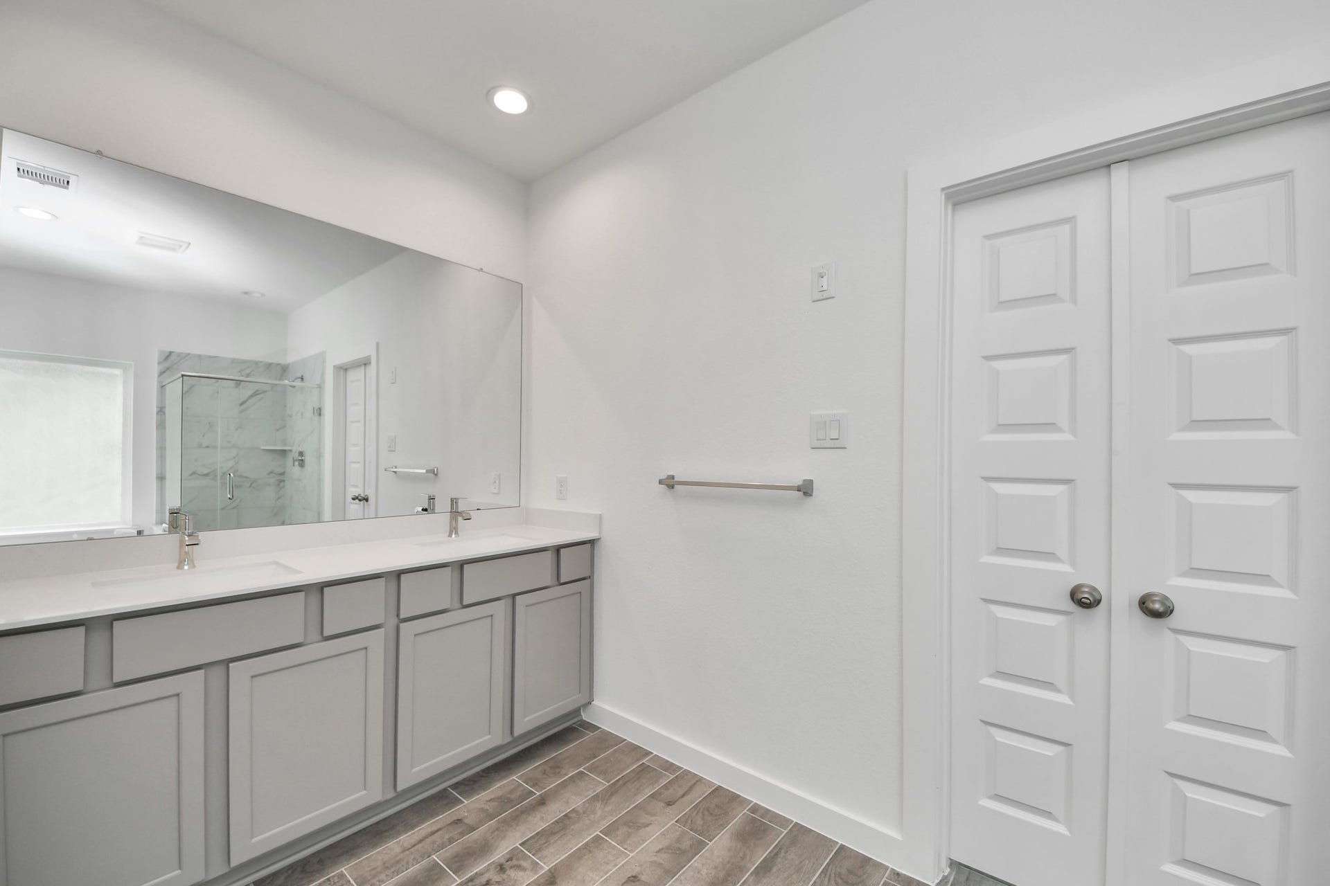 63 Knight Bayou Drive, Dayton, TX 77535 Elevate your daily routine at the elegant vanity, now equipped with double sinks, light countertops, modern hardware, and beautiful recessed lights. Sample photo of completed home with similar floor plan. Actual colors and selections may vary.