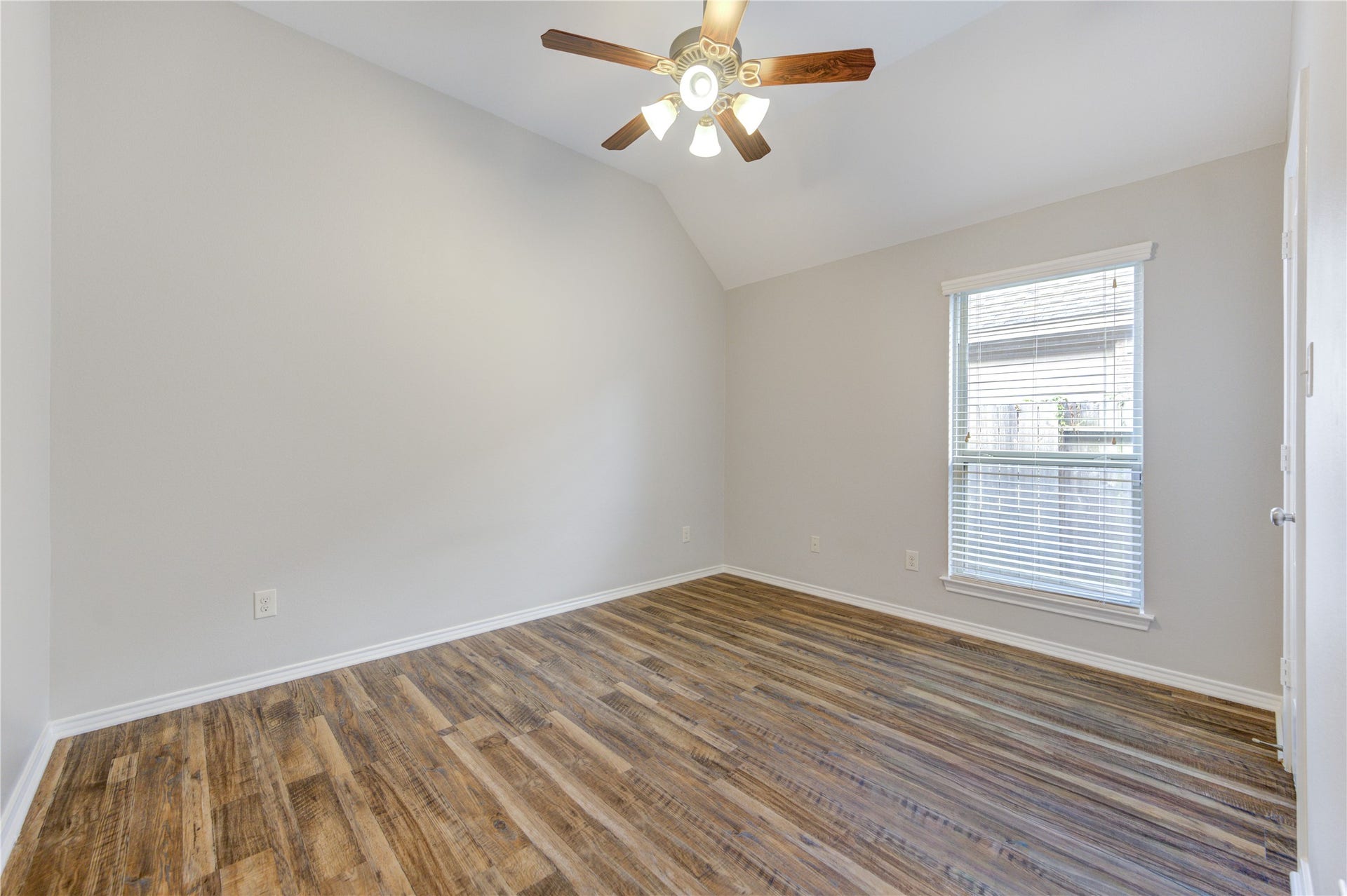 27407 Gatlin Lane, Spring, TX 77386 Light-filled bedroom with warm wood-look vinyl plank flooring and large windows. A comfortable retreat ready for rest.