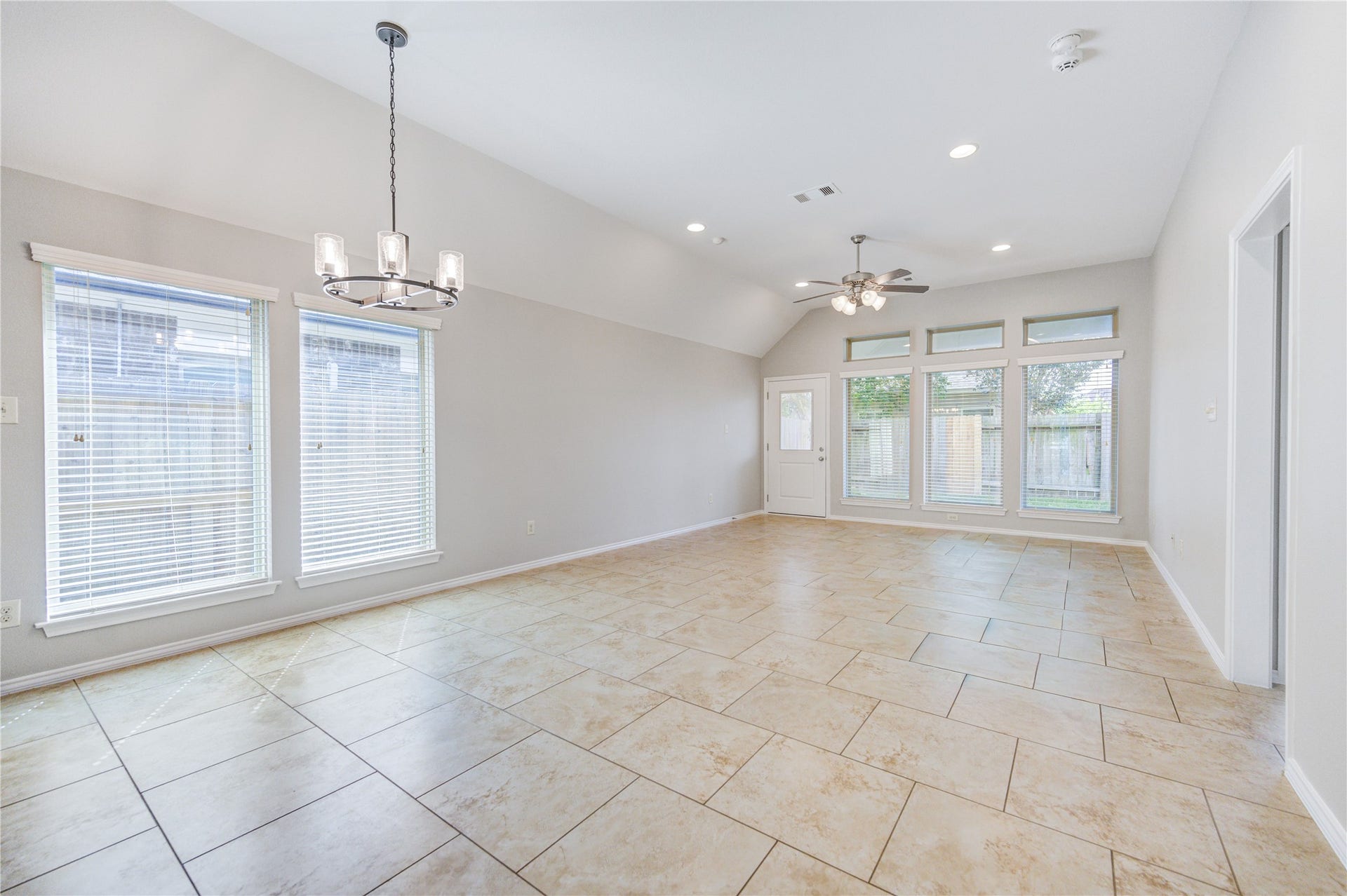 27407 Gatlin Lane, Spring, TX 77386 Open-concept living and dining area with tile flooring and oversized windows. A flexible space ready to fit your lifestyle.