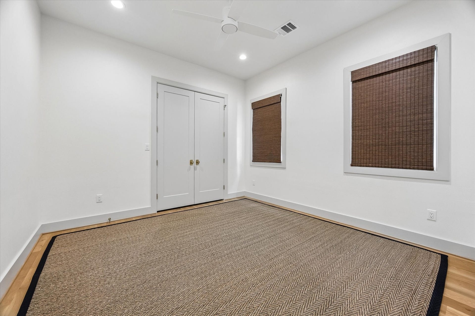 704 Teetshorn Street, Houston, TX 77009 Spacious secondary bedroom with hardwood floors, woven shades and easy access to the shared bath.