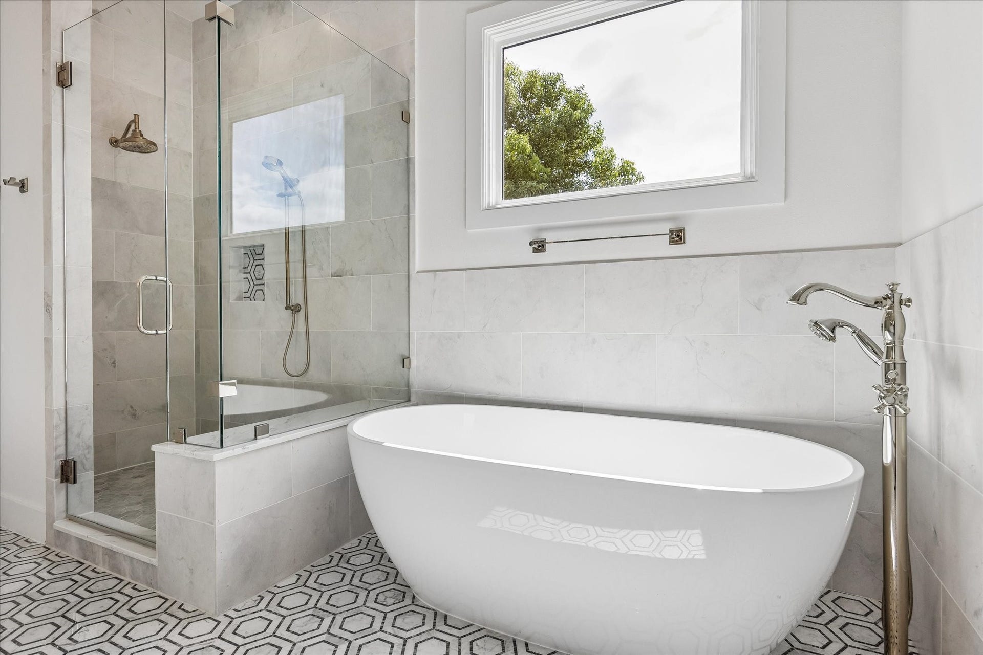 704 Teetshorn Street, Houston, TX 77009 Freestanding soaking tub set beneath a large window, positioned beside the oversized walk-in shower.