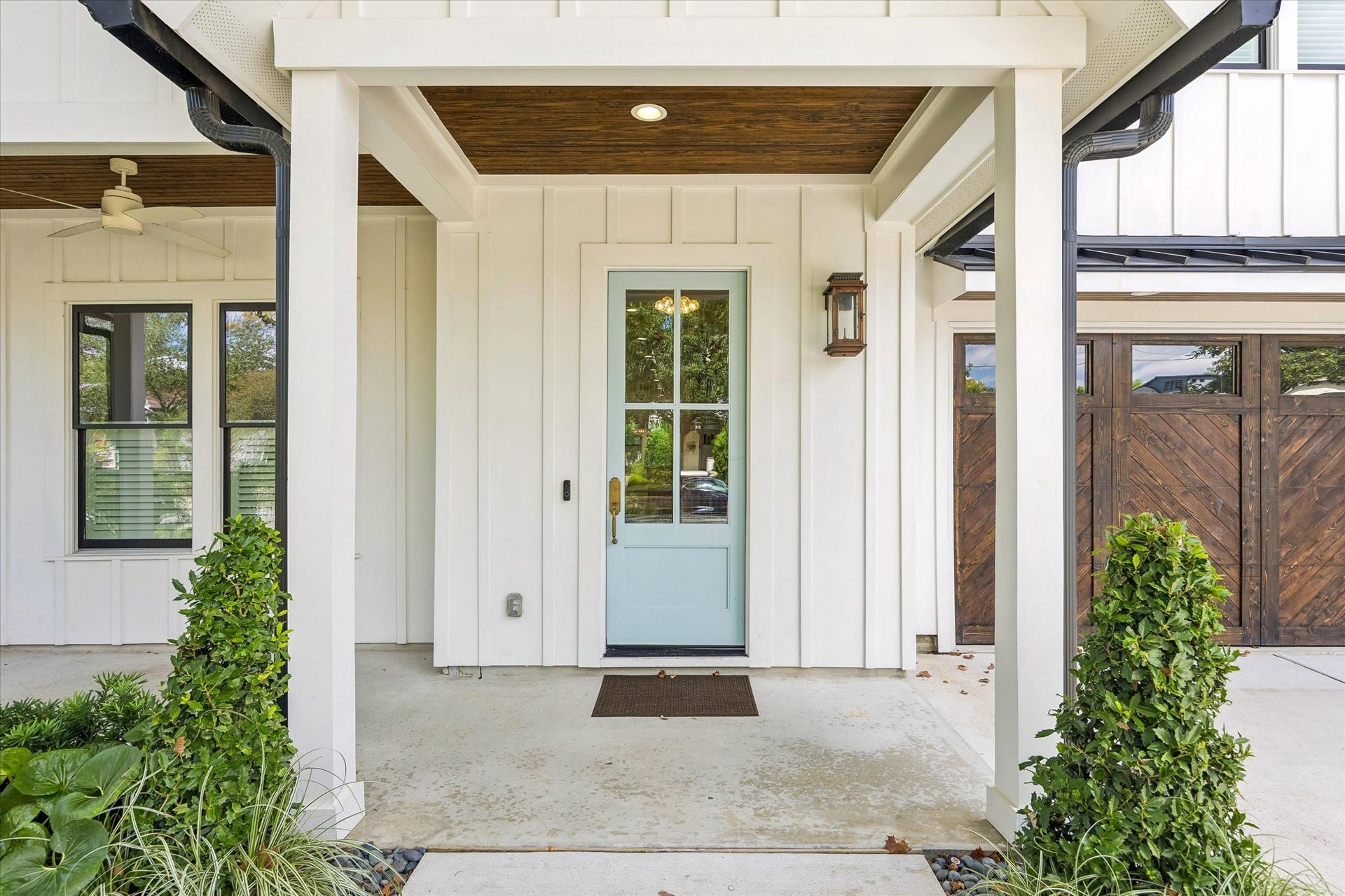704 Teetshorn Street, Houston, TX 77009 Covered front porch with wood-accented ceiling, glass-paneled entry door and clean architectural detailing.