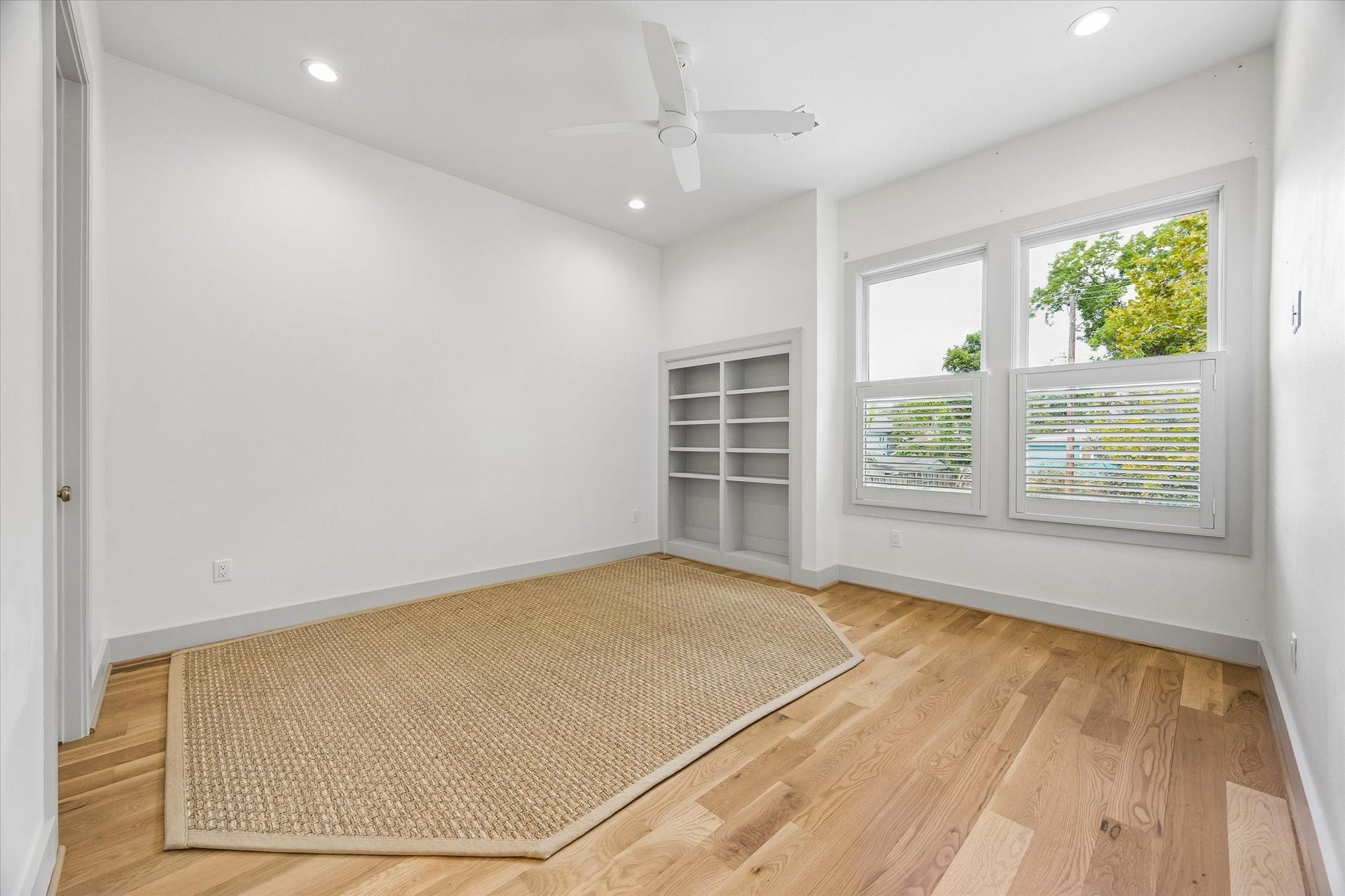 704 Teetshorn Street, Houston, TX 77009 Another secondary bedroom features hardwood floors, built-in shelving and front-facing windows with plantation shutters.