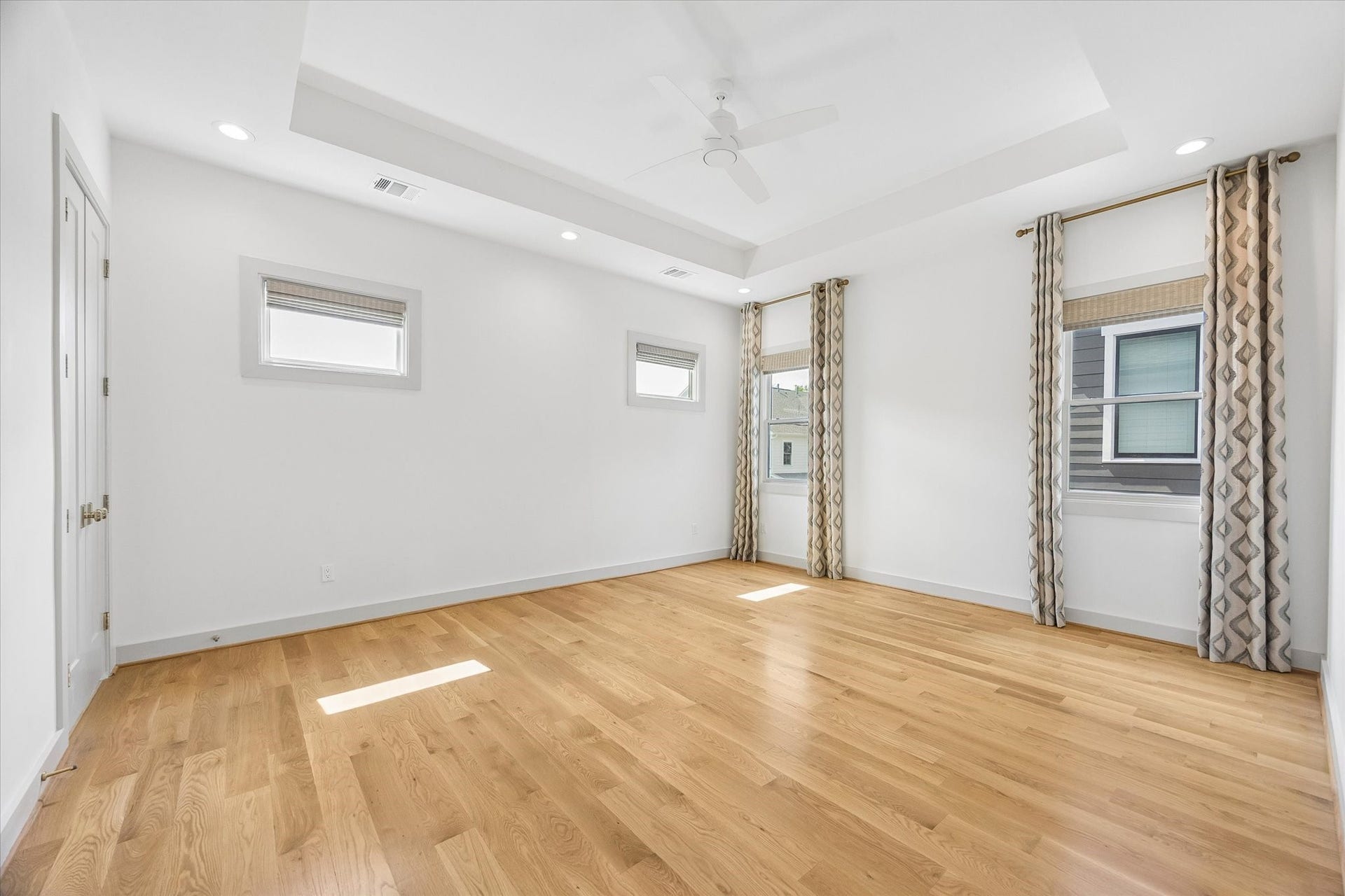 704 Teetshorn Street, Houston, TX 77009 Spacious primary suite with hardwood floors, tray ceiling and multiple windows for abundant natural light.