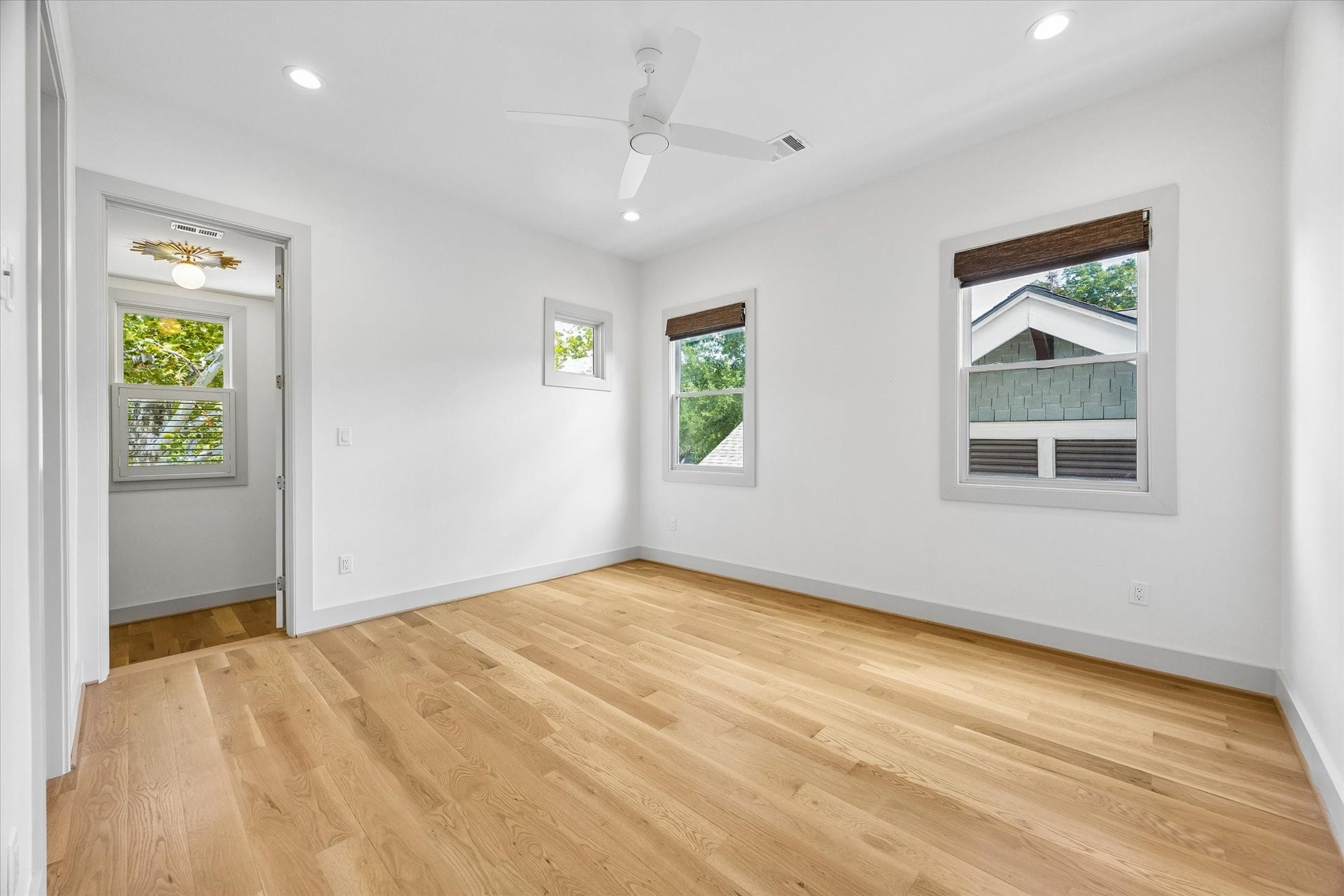 704 Teetshorn Street, Houston, TX 77009 Bright secondary bedroom with hardwood floors, ceiling fan and multiple windows for natural light.