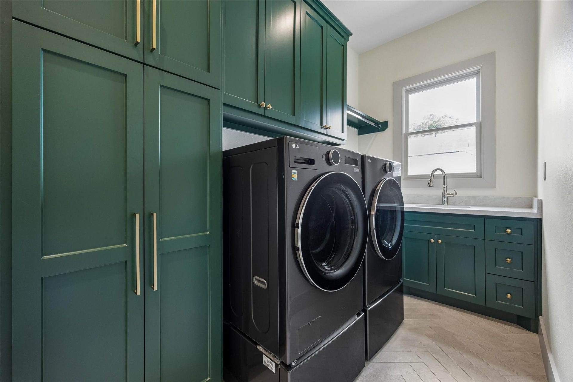 704 Teetshorn Street, Houston, TX 77009 Well-appointed second-floor utility room with deep green cabinetry, brass hardware, sink and ample storage.