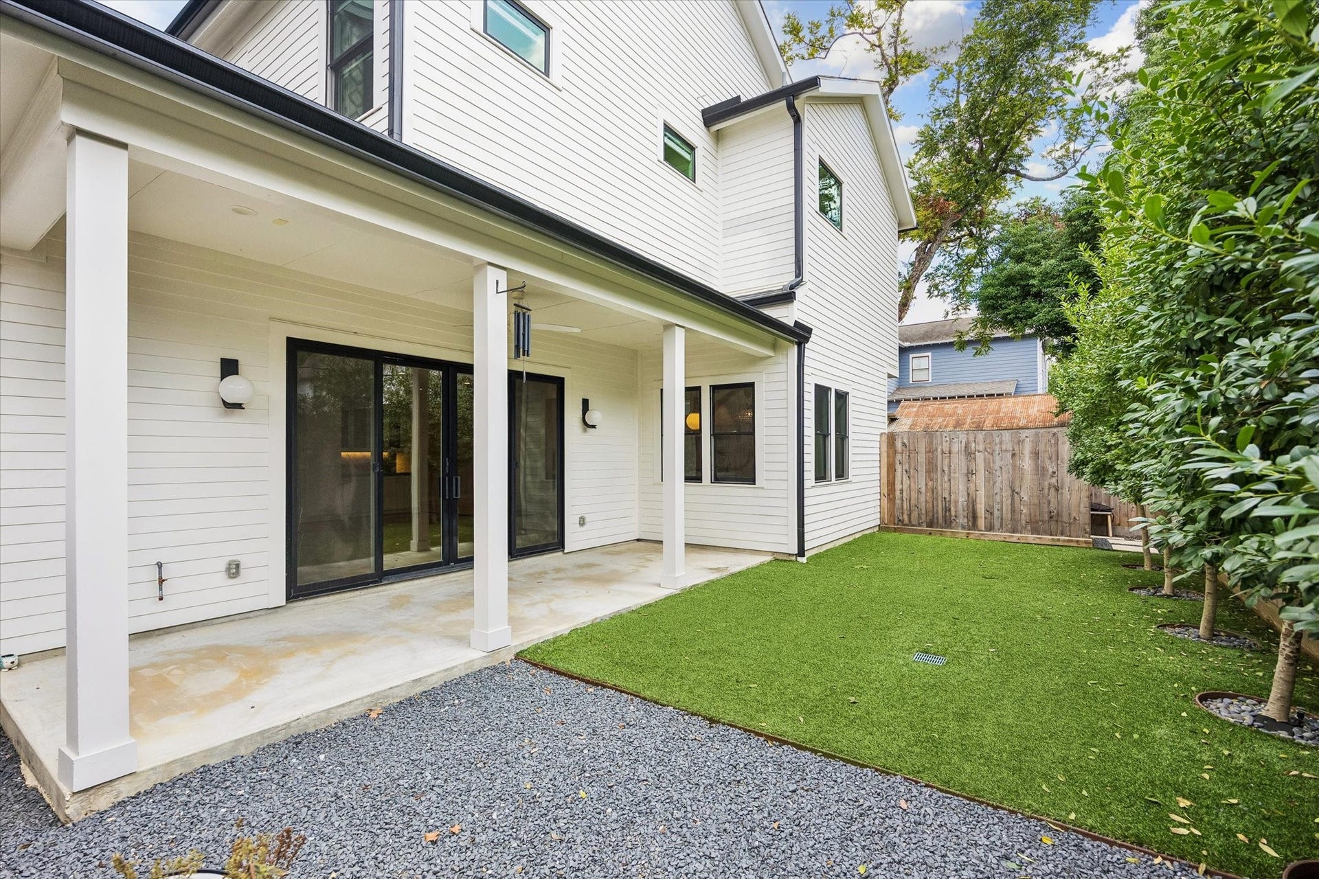 704 Teetshorn Street, Houston, TX 77009 A wider view highlights the covered patio, low-maintenance turf and private green space beyond.
