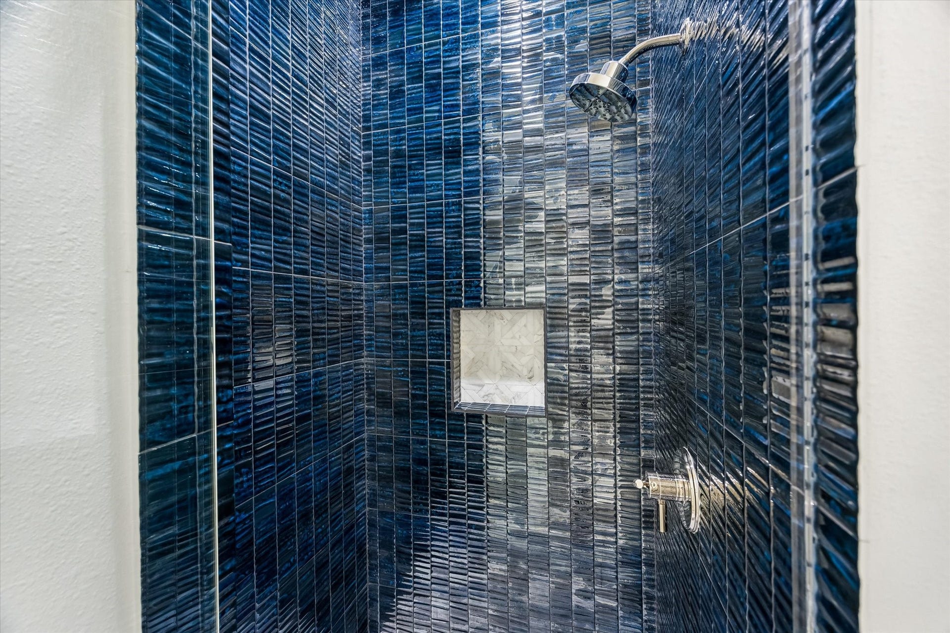 704 Teetshorn Street, Houston, TX 77009 The full bath includes a striking walk-in shower wrapped in deep blue tile for a bold, tailored finish.