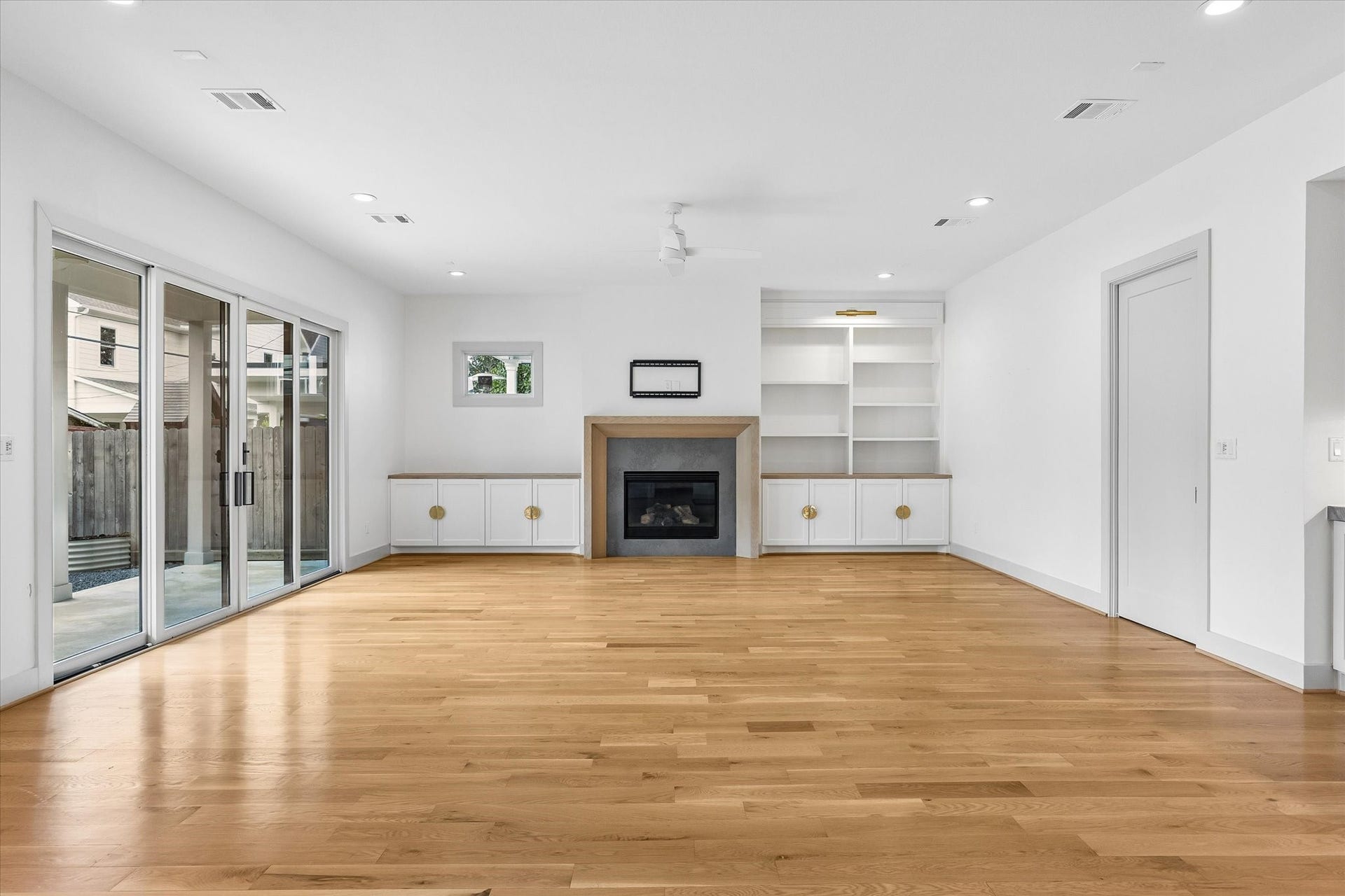 704 Teetshorn Street, Houston, TX 77009 Floor-to-ceiling glass doors connect the living room to the covered patio and backyard, creating an easy indoor-outdoor flow.