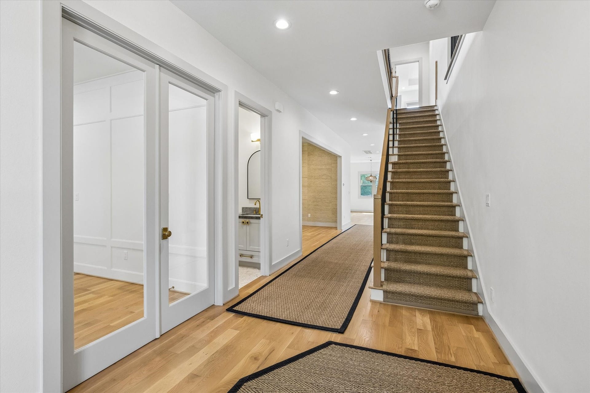 704 Teetshorn Street, Houston, TX 77009 Bright entry with hardwood floors, custom millwork and staircase with warm wood treads and black metal balusters.