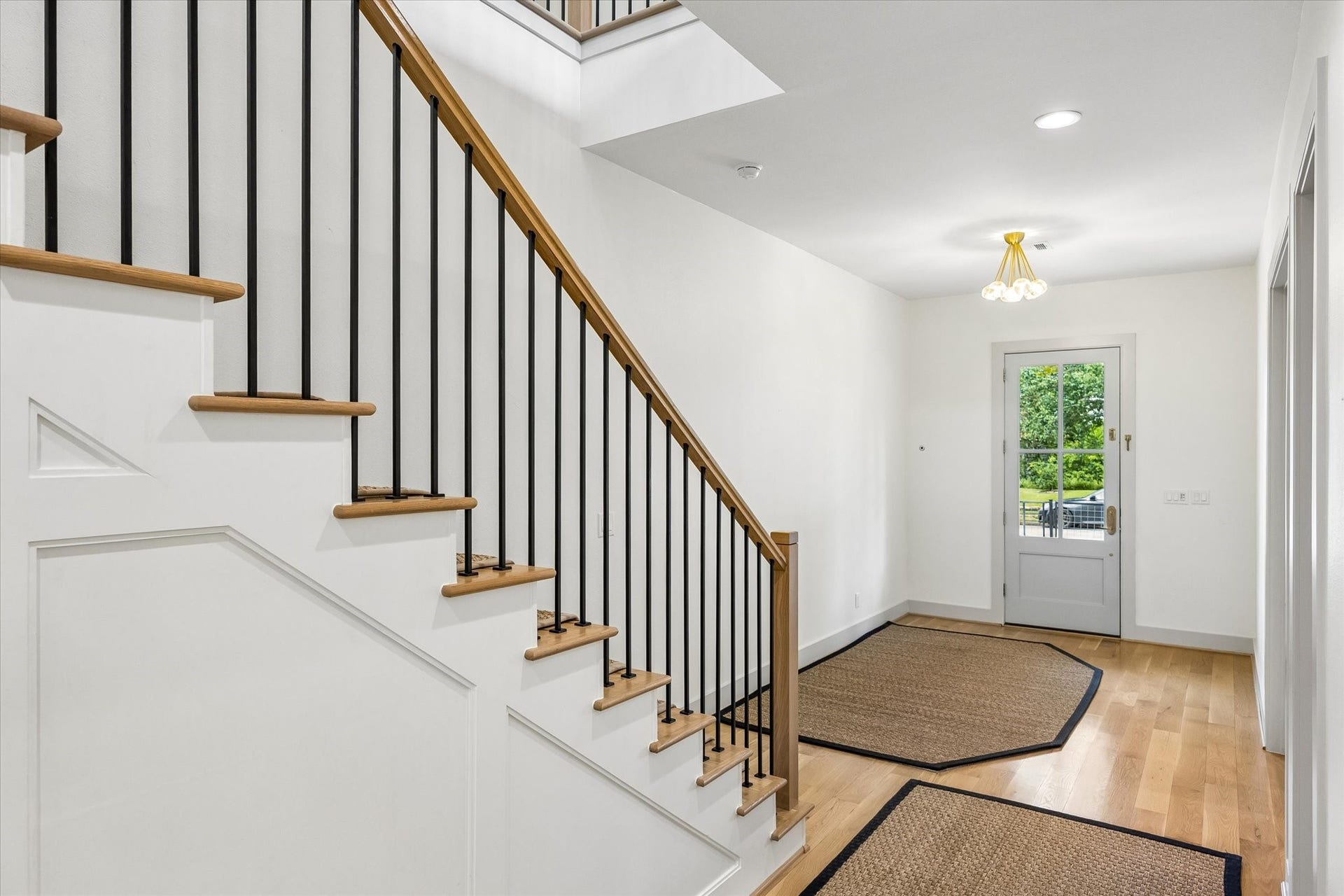704 Teetshorn Street, Houston, TX 77009 Bright entry with hardwood floors, custom millwork and staircase with warm wood treads and black metal balusters.