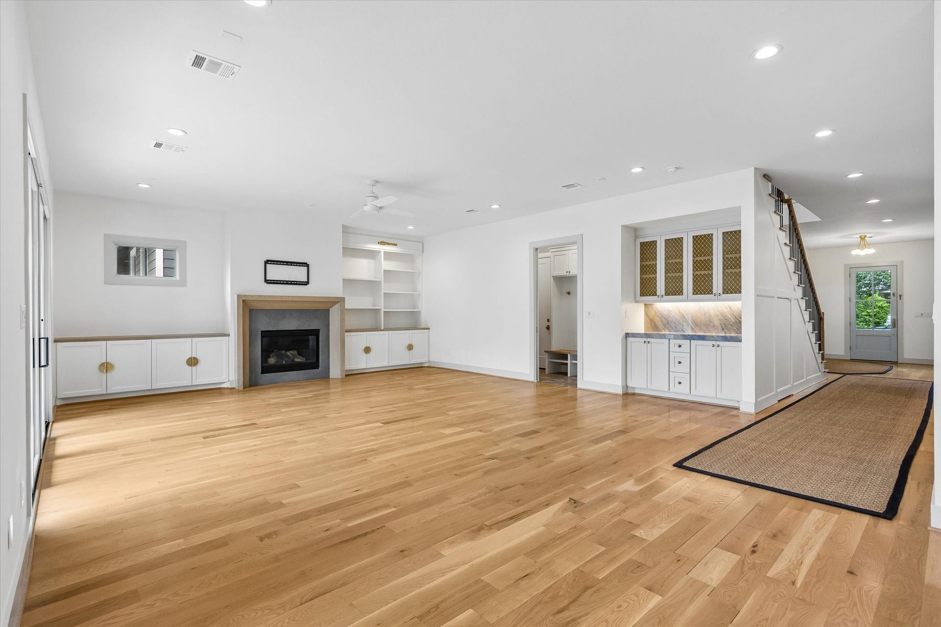 704 Teetshorn Street, Houston, TX 77009 Expansive living room with hardwood floors, custom built-ins, a fireplace and abundant natural light.