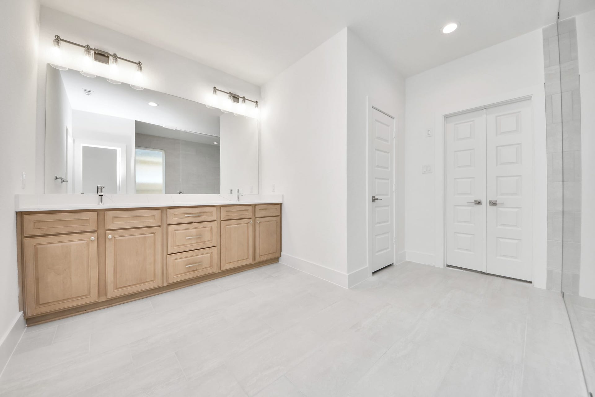 3221 Skerne Spring Drive, Spring, TX 77373 Elevate your daily routine at the elegant vanity, now equipped with double sinks, light countertops, modern hardware, and beautiful vanity lights. Sample photo of completed home with similar floor plan. Actual colors and selections may vary.