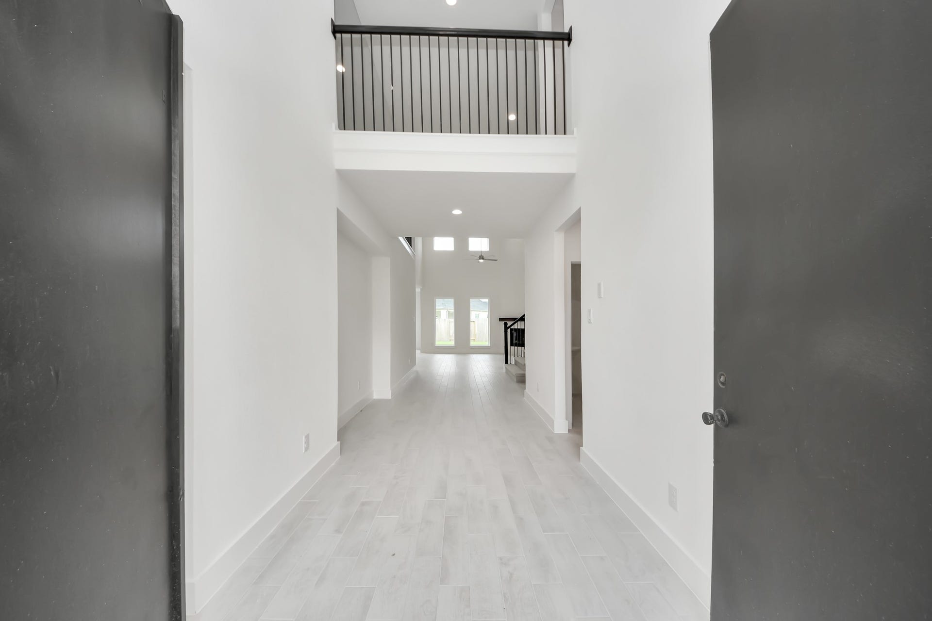 3221 Skerne Spring Drive, Spring, TX 77373 As you step into the threshold of this luxurious home, you'll soon be welcomed by an elegant glass door (to be installed). Inside, soaring ceilings amplify the spaciousness, while the refined wood-look tile flooring and oversized baseboards exude sophistication and charm. Sample photo of completed home with similar floor plan. Actual colors and selections may vary.