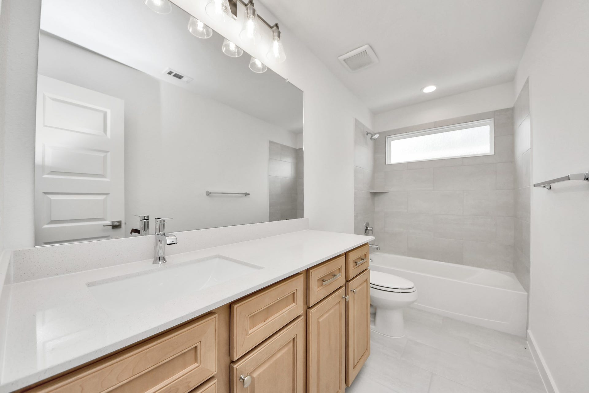 3221 Skerne Spring Drive, Spring, TX 77373 Secondary bath features tile flooring, bath/shower combo with tile surround, light stained wood cabinets, beautiful light countertop. Sample photo of completed home with similar floor plan. Actual colors and selections may vary.