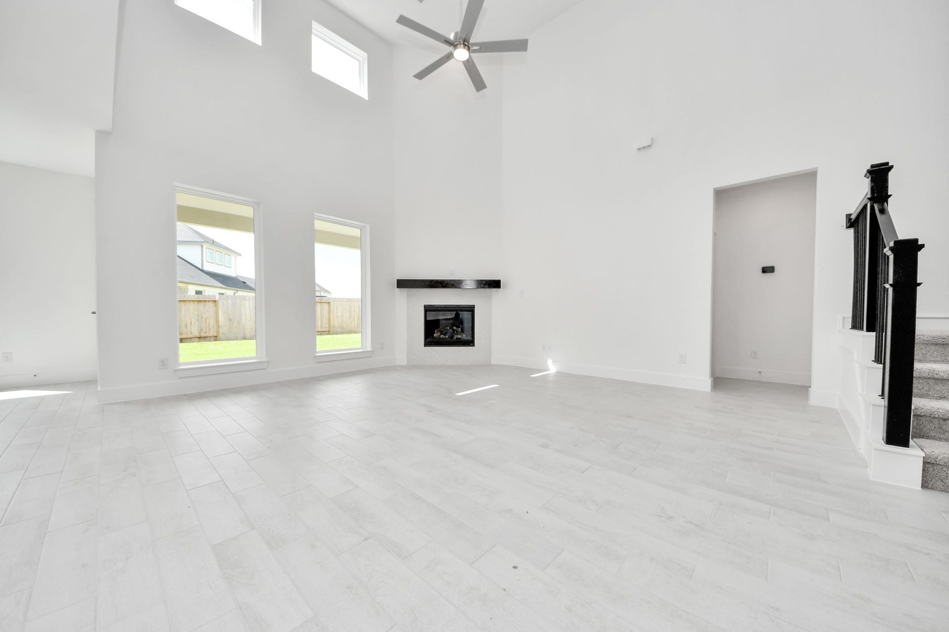 3221 Skerne Spring Drive, Spring, TX 77373 Family room flooded with natural light through the expansive windows. The premium tile flooring adds a touch of luxury to the space, creating the perfect setting for relaxing moments and cherished gatherings with loved ones. v