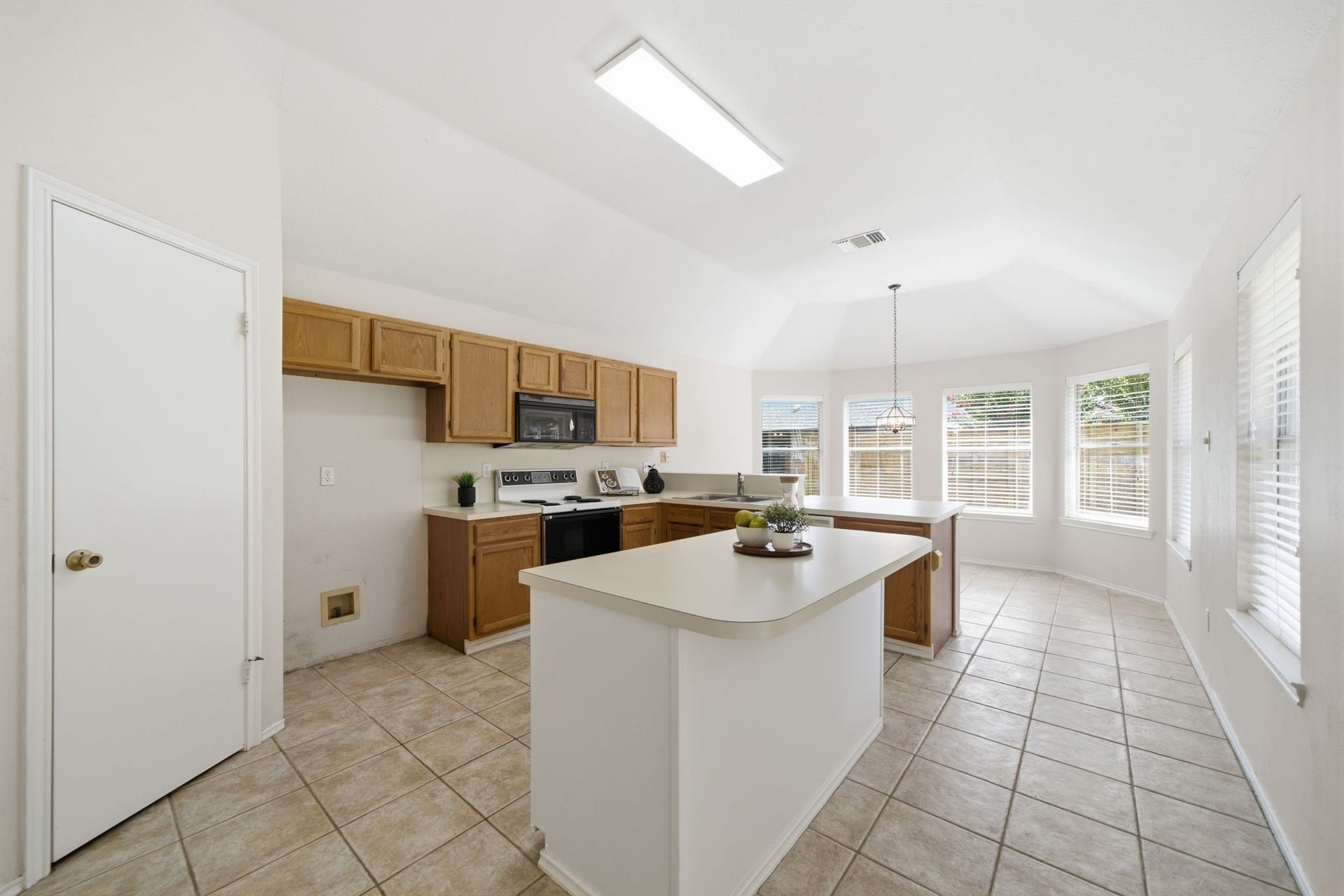 707 Laurel Grove Lane, Pearland, TX 77584 Island kitchen overlooks breakfast area/backyard with a wall of windows.