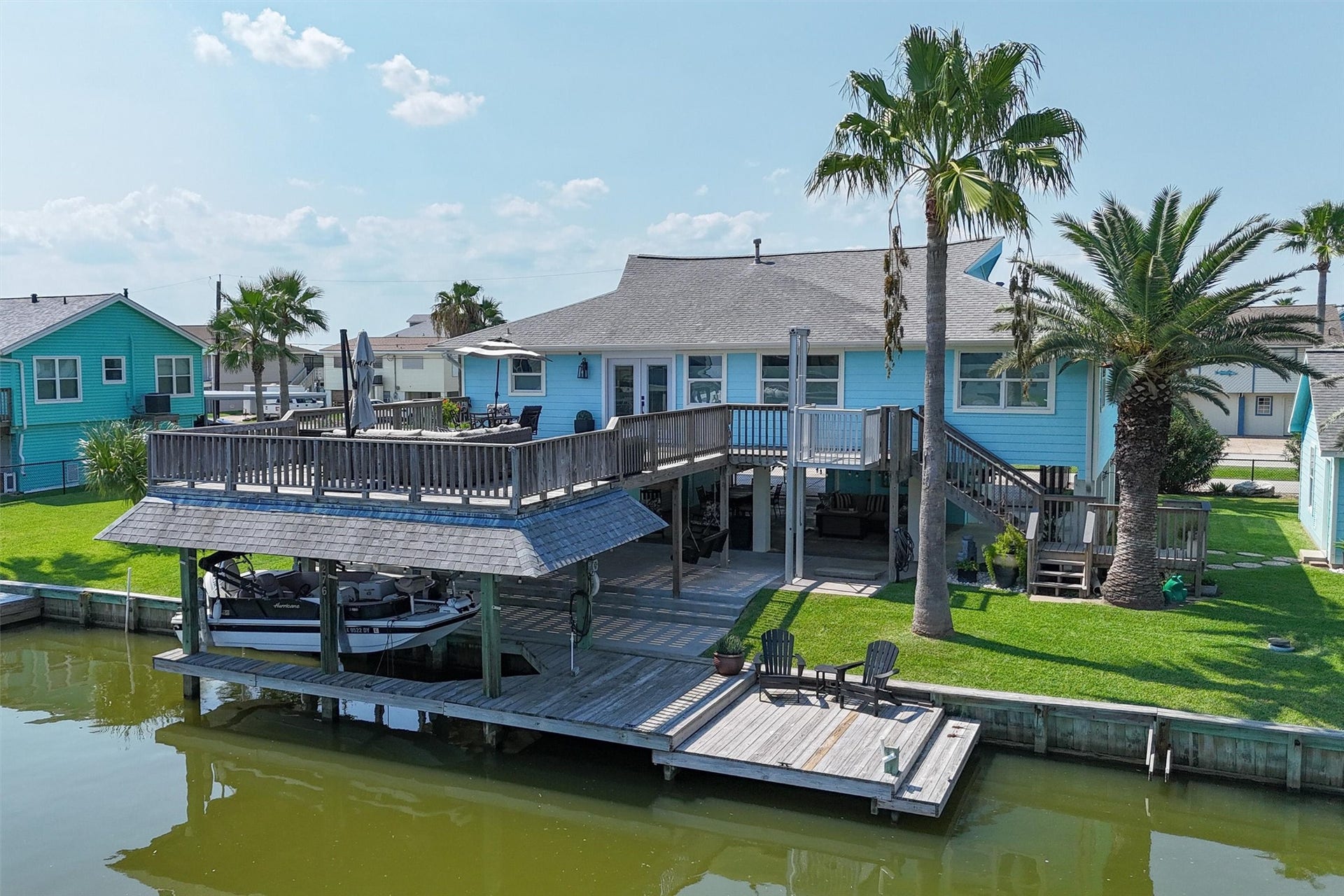 276 Barracuda Street, Bayou Vista, TX 77563 The water side of the home boasts stunning views and direct access to the canal, framed by lush landscaping and a spacious deck perfect for relaxing or entertaining. Large windows and open spaces invite natural light and gentle breezes, creating a serene waterfront retreat where every day feels like a vacation