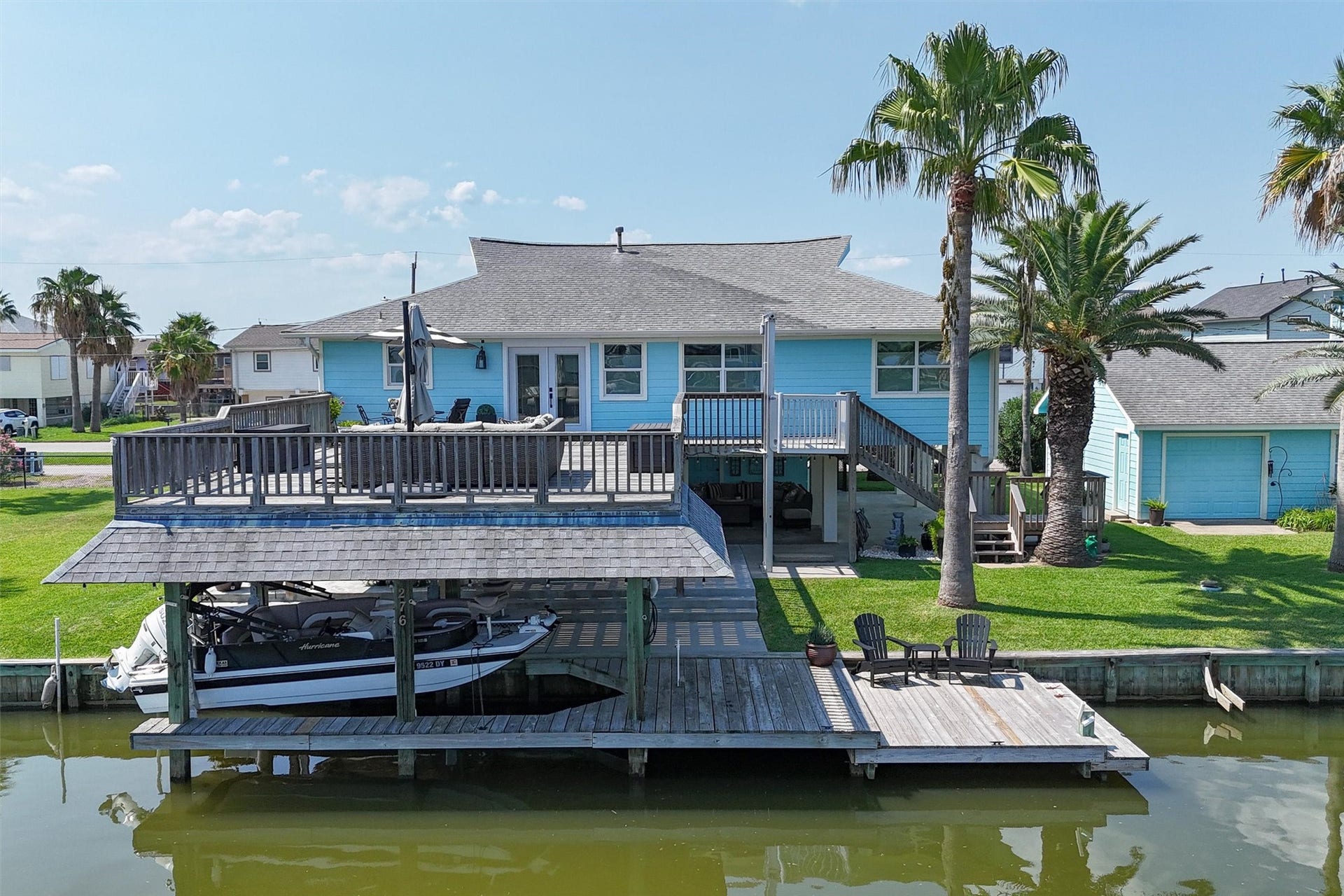 276 Barracuda Street, Bayou Vista, TX 77563 The oversized upper party deck on this east-facing property is the ultimate gathering spot, surrounded by beautiful palm trees that create a perfect tropical ambiance. Enjoy ample space for fishing from the dock and easy boat access with your own private slip