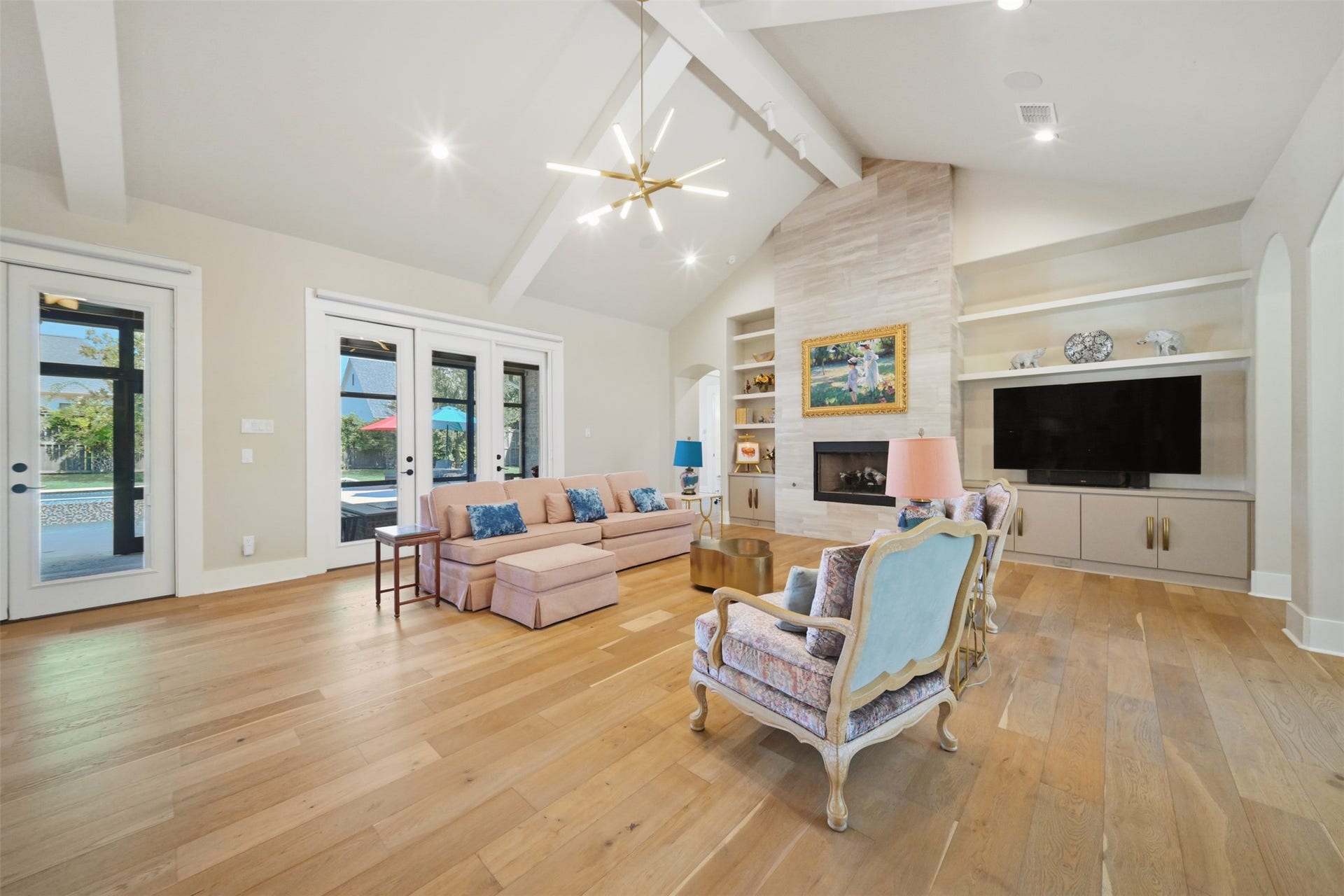5117 Inverness Drive, Bryan, TX 77802 Spacious living area with soaring vaulted ceilings, gas-log fireplace with tile surround, and custom built-in cabinetry.