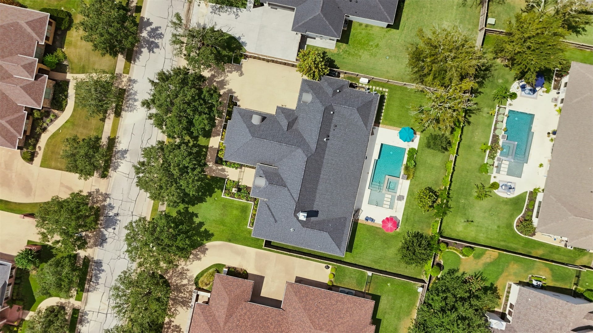 5117 Inverness Drive, Bryan, TX 77802 Aerial view of the entire property highlighting the homes footprint, generous lot, driveway, sidewalks, pool, and surrounding green space.