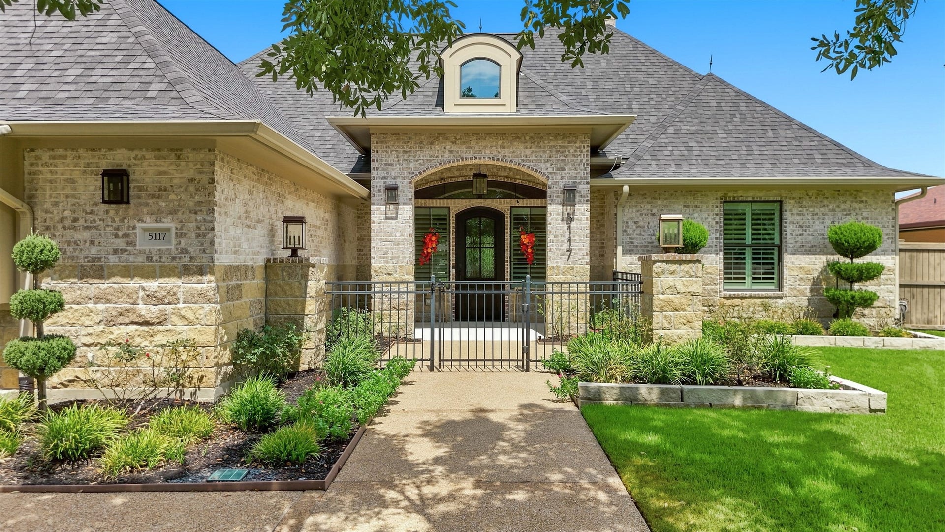 5117 Inverness Drive, Bryan, TX 77802 Gated front courtyard creates a welcoming entrance leading to the striking metal front door.