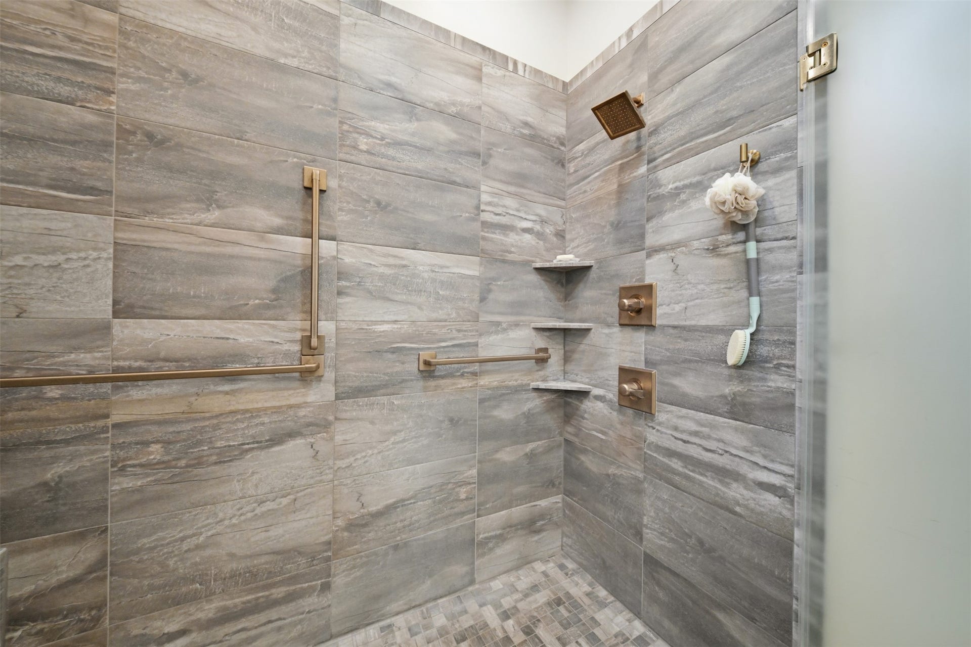5117 Inverness Drive, Bryan, TX 77802 Luxurious walk-in shower featuring beautiful stonework and custom fixtures.