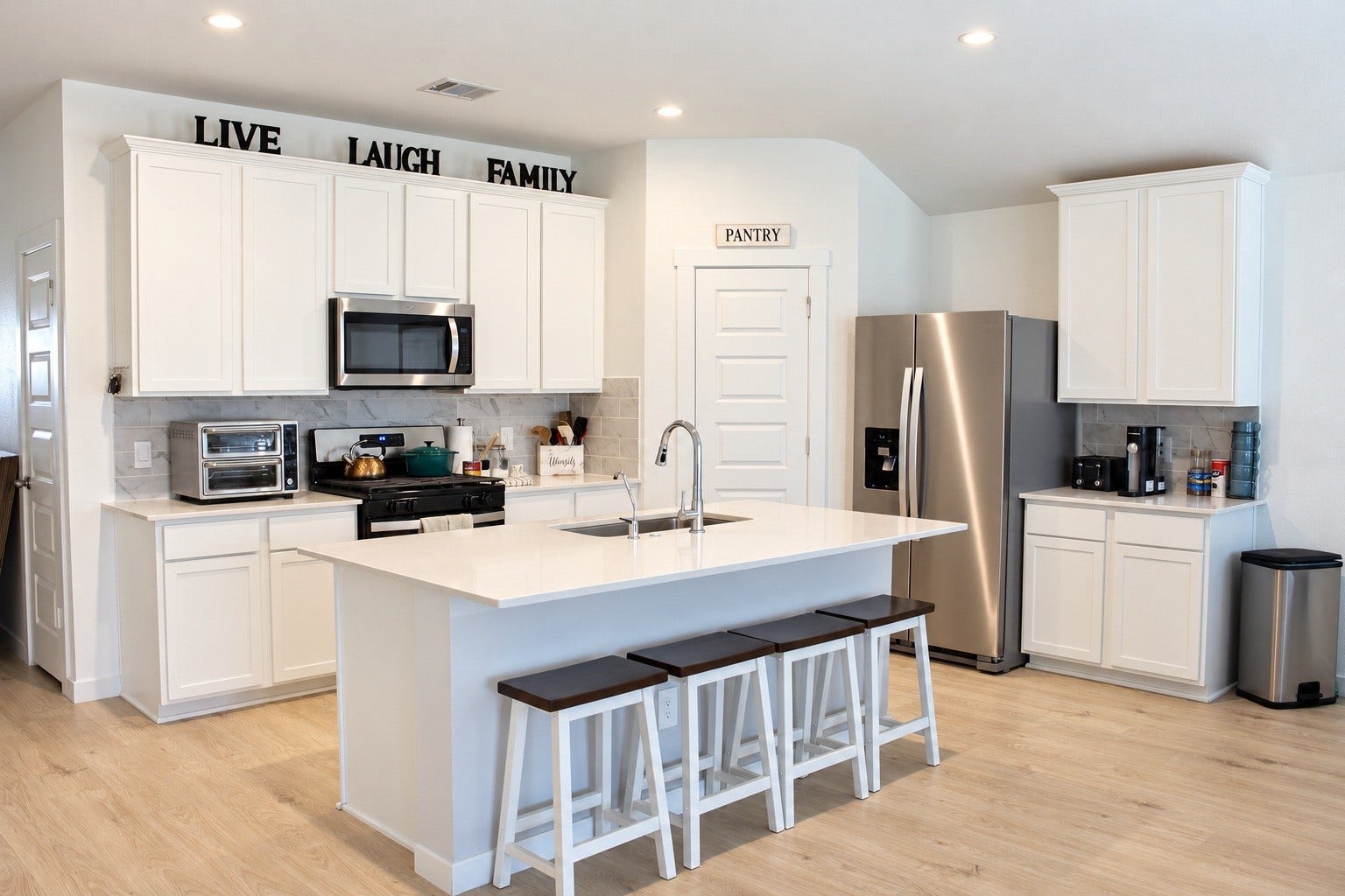 Modern Kitchen Featuring Island, Stainless Steel Appliances, and Walk-In Pantry.