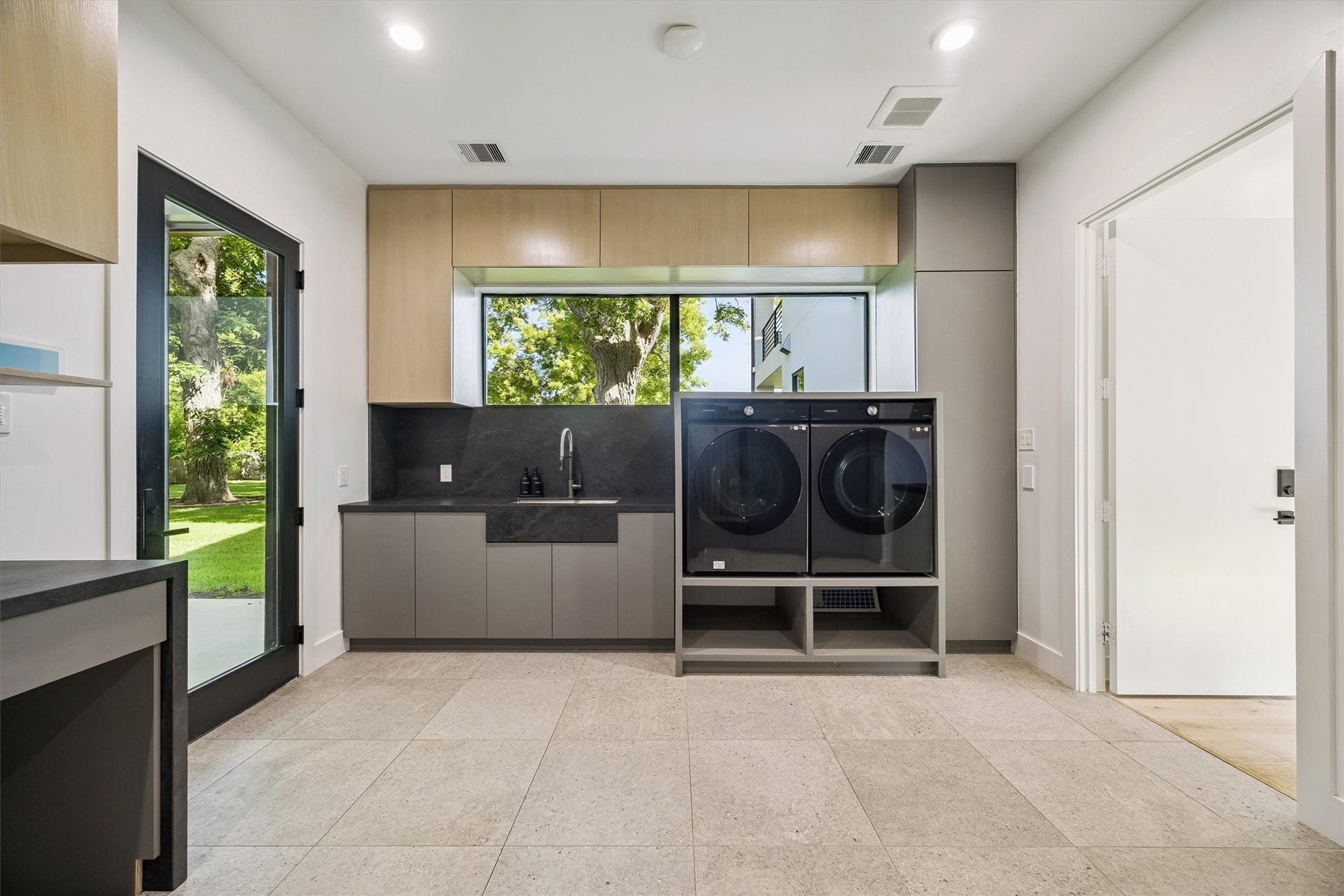 5210 Manor Drive, Sugar Land, TX 77479 Function meets refined design in this spacious laundry room, complete with generous cabinetry, modern appliances, and a large window overlooking the picturesque grounds.