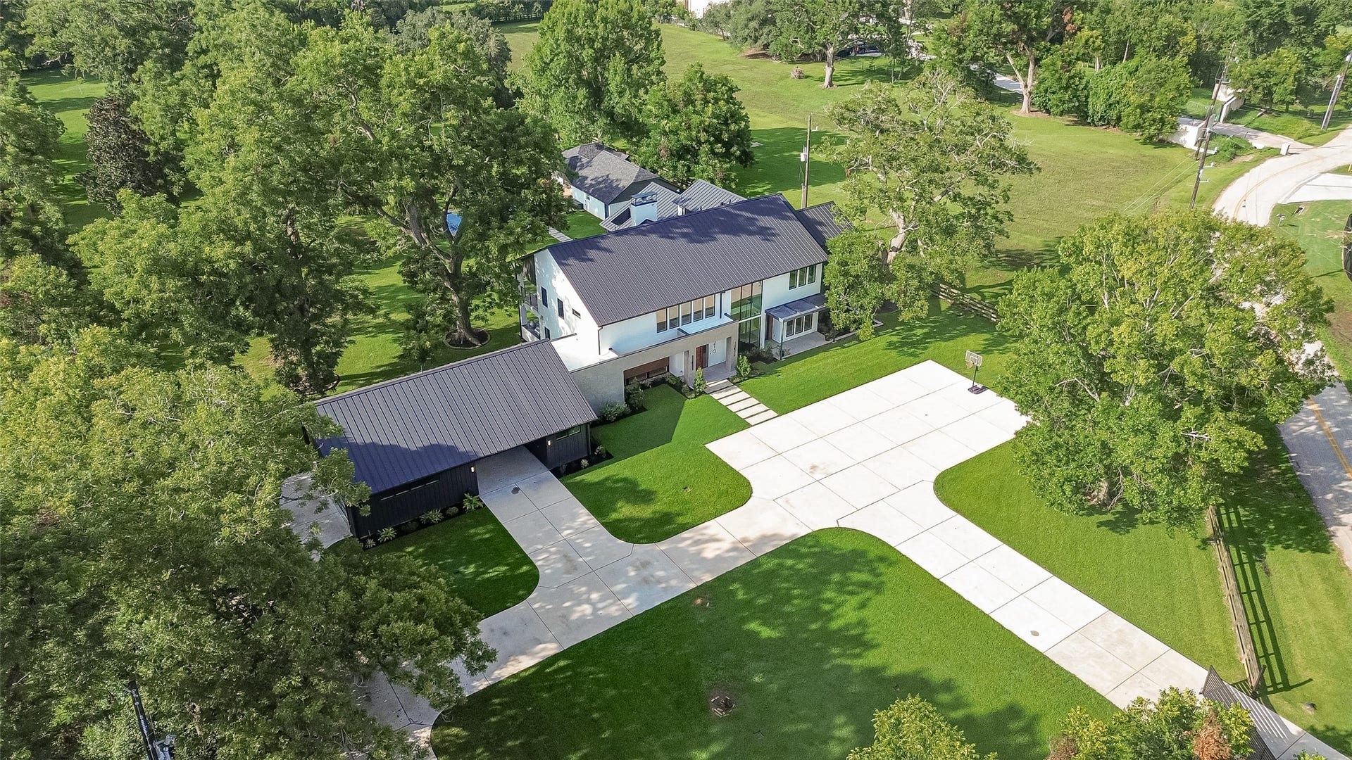 5210 Manor Drive, Sugar Land, TX 77479 An elevated perspective reveals the home's distinctive architecture, generous motor court, and beautifully landscaped setting, offering an early glimpse of the privacy and scale that define this exceptional property.