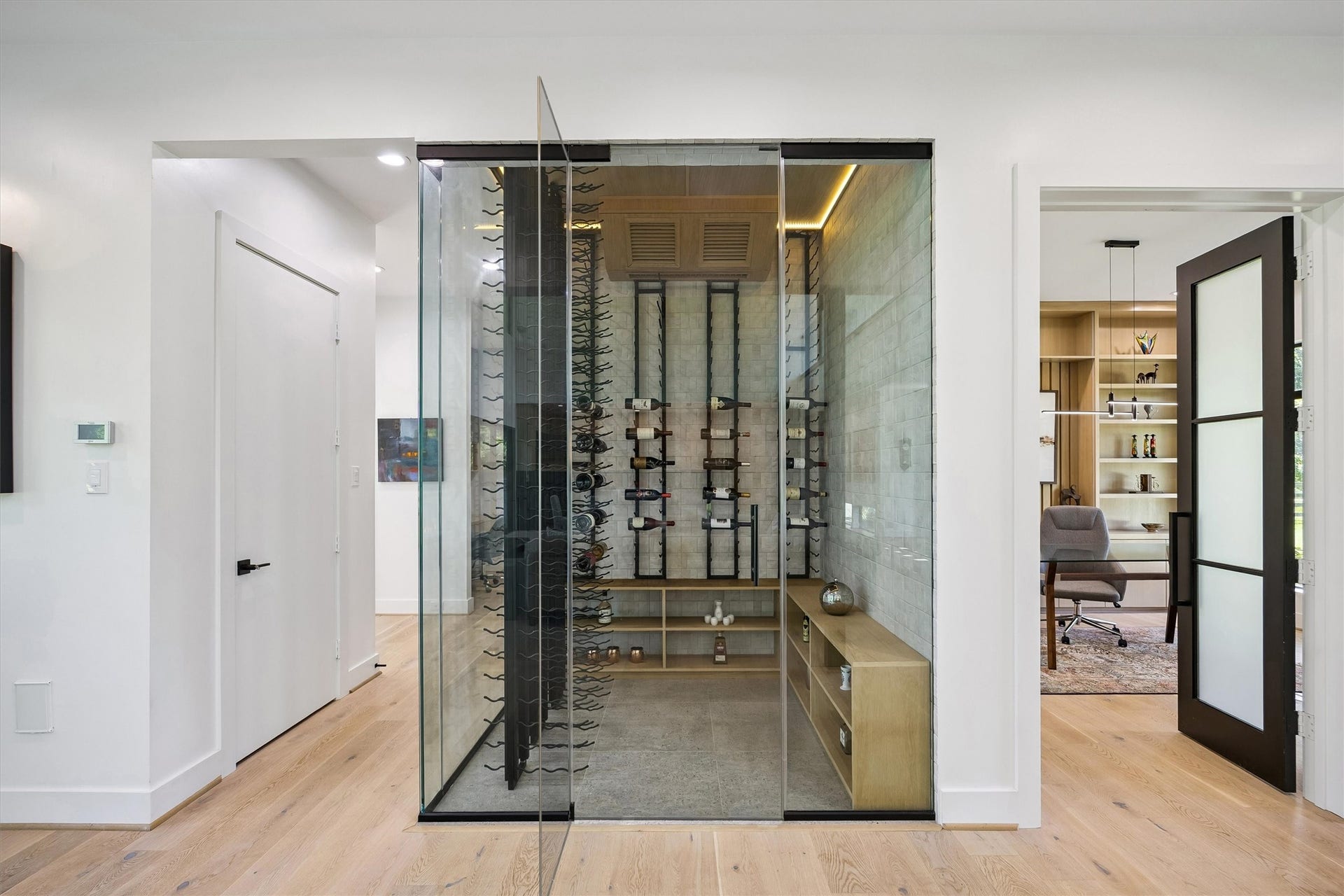5210 Manor Drive, Sugar Land, TX 77479 A sophisticated glass-enclosed wine display introduces an unexpected touch of luxury, combining architectural transparency, illuminated storage, and a striking presentation for a treasured collection.
