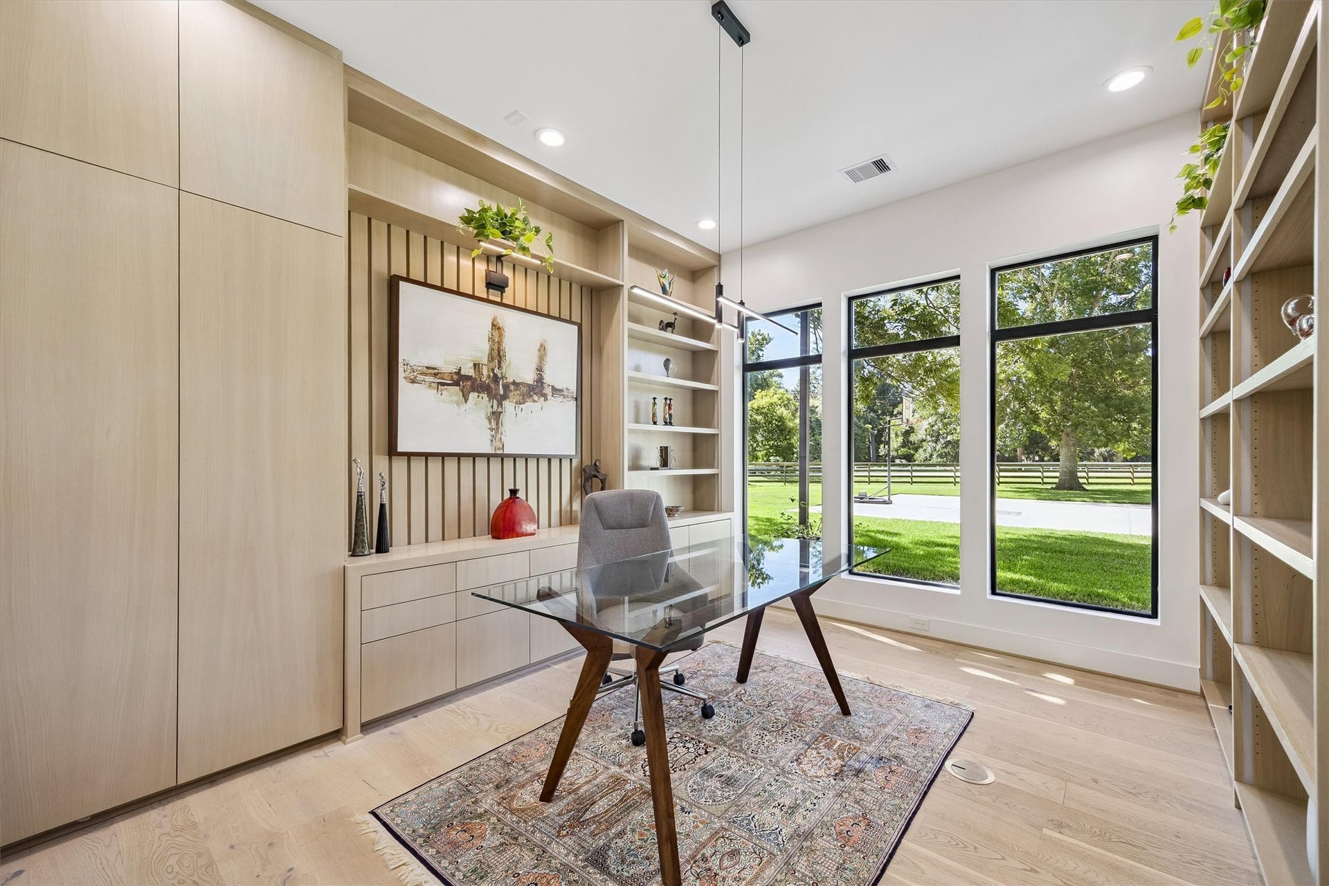 5210 Manor Drive, Sugar Land, TX 77479 An inspiring retreat for work or quiet reflection, this beautifully appointed study features custom shelving, elegant built-ins, and expansive windows framing peaceful views of the surrounding landscape.