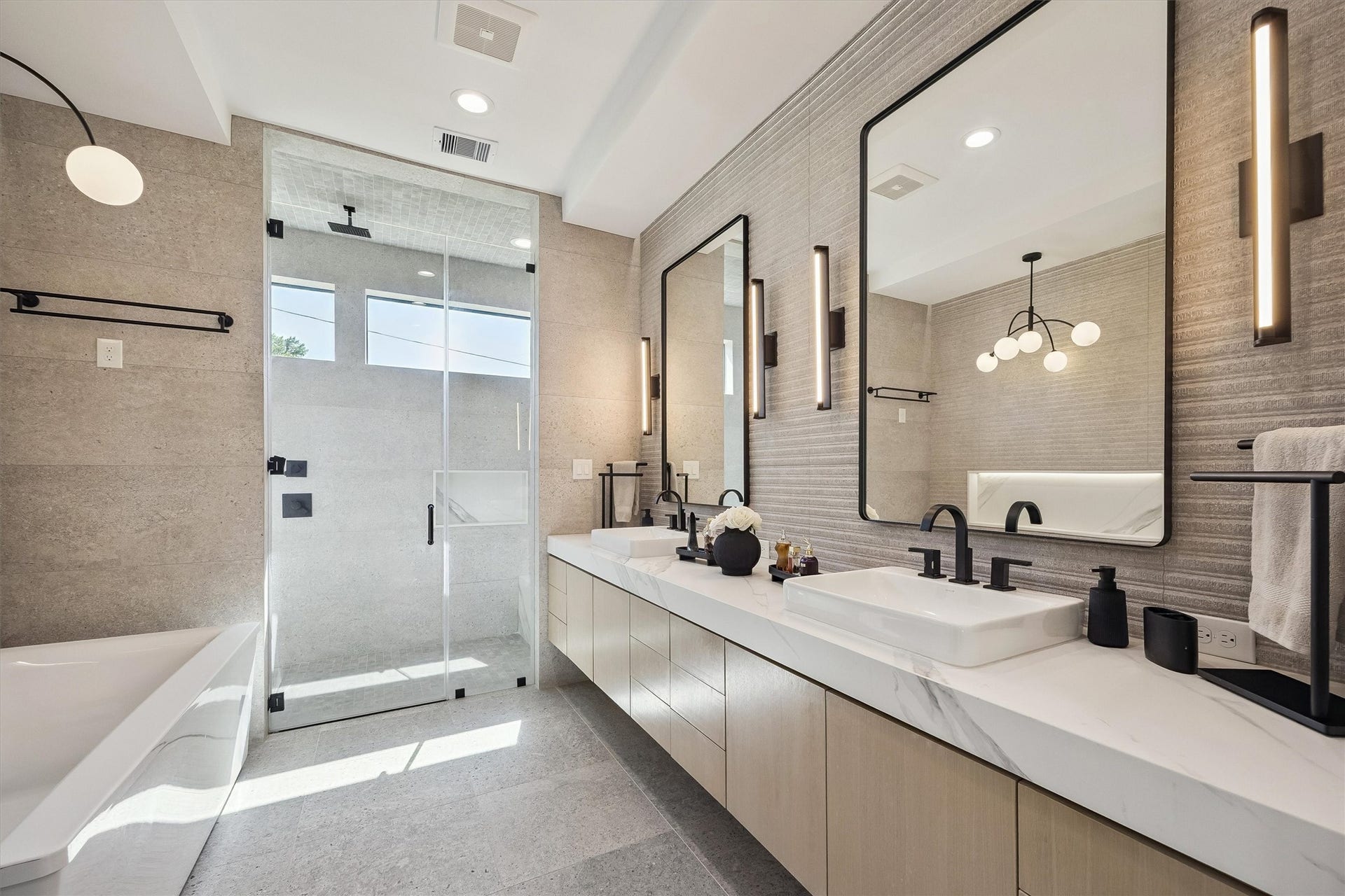 5210 Manor Drive, Sugar Land, TX 77479 A refined combination of elegant finishes, dual vanities, contemporary lighting, and a glass-enclosed shower transforms the primary bath into a luxurious daily retreat.